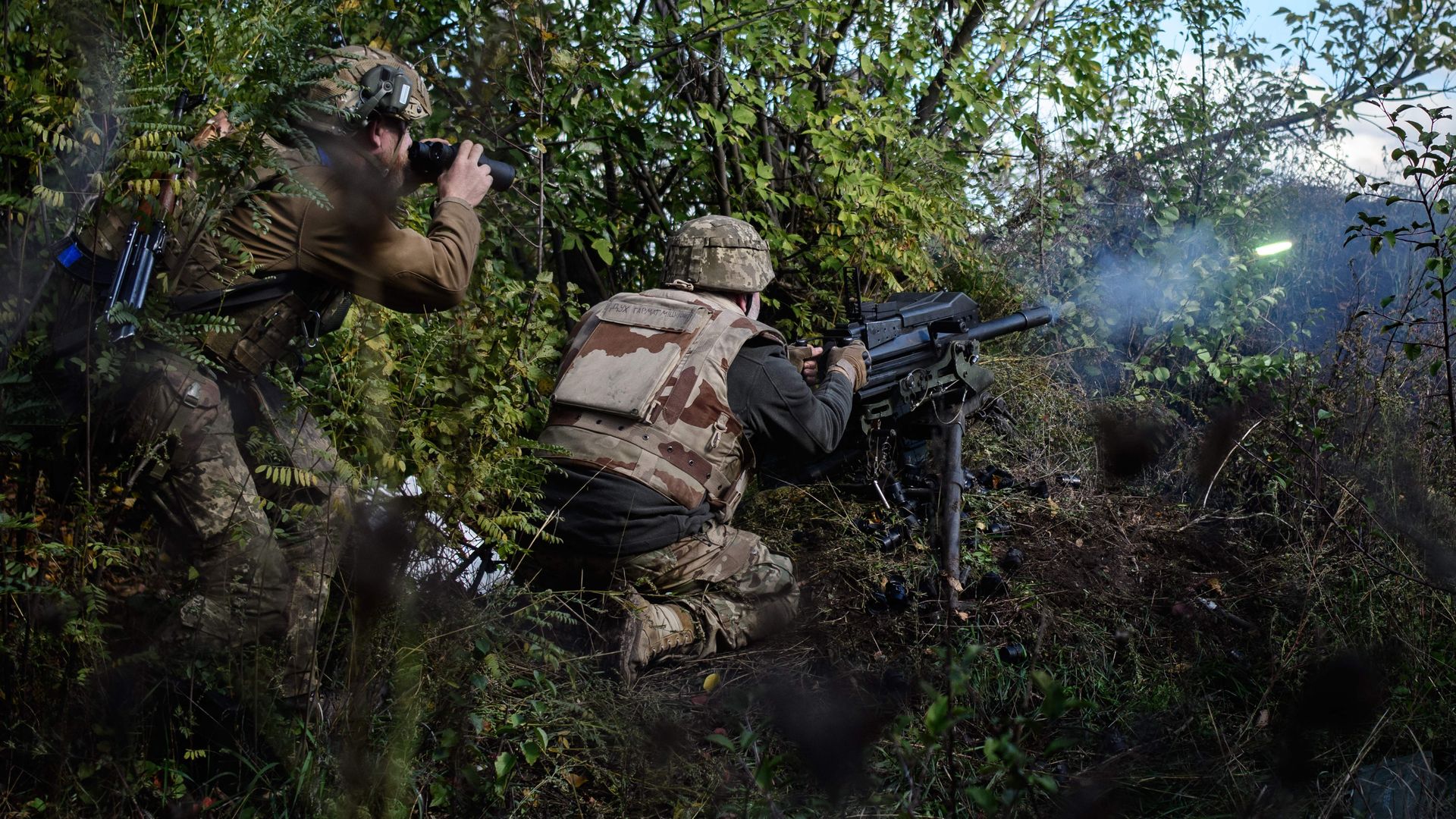 A soldier of Ukraine's 5th Regiment of Assault Infantry fires a US-made MK-19 automatic grenade launcher towards Russian positions on Cct. 12