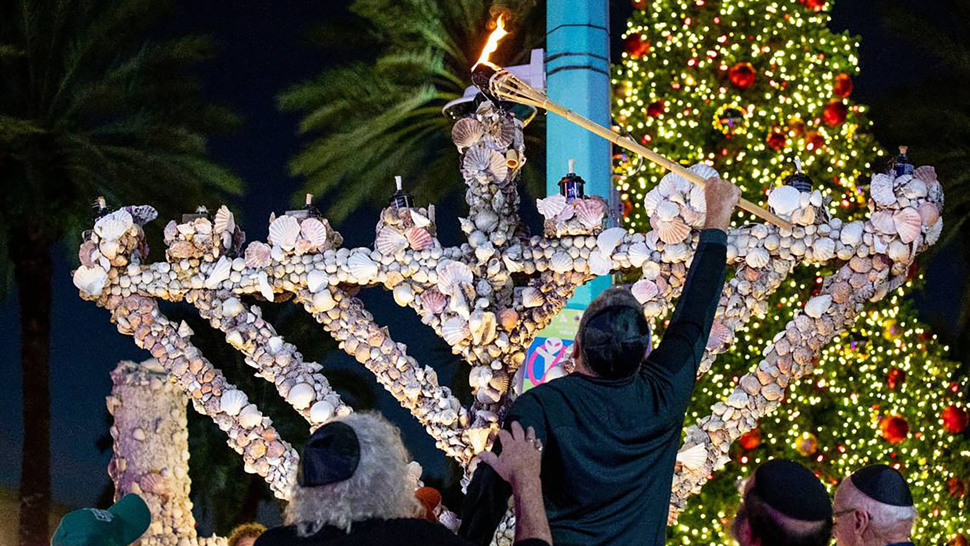 The community gathered to light artist Roger Abramson's unique seashell covered menorah in 2021 to mark the first night of Hanukkah on Lincoln Road in Miami Beach. Abramson, 87, created the unique piece of art 20 years ago. Lighting celebrations will begin Thursday across South Florida. (Daniel A. V