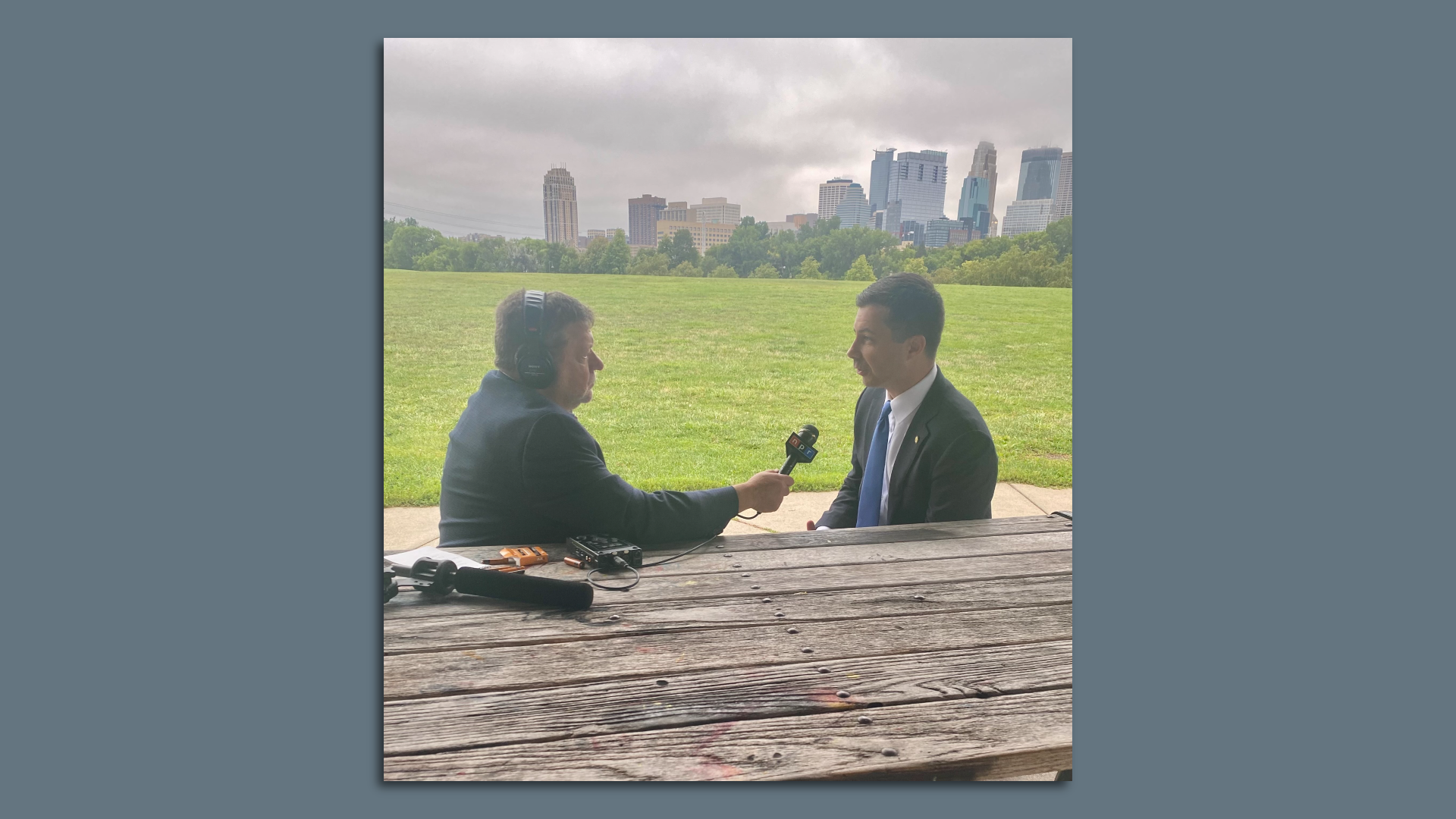 Photo of a man interviewing another man with a microphone