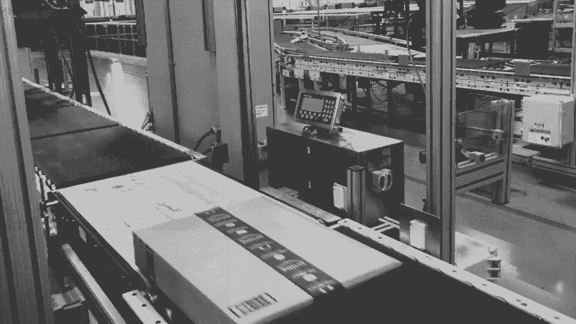 A black and white GIF of an Amazon box on a conveyer belt