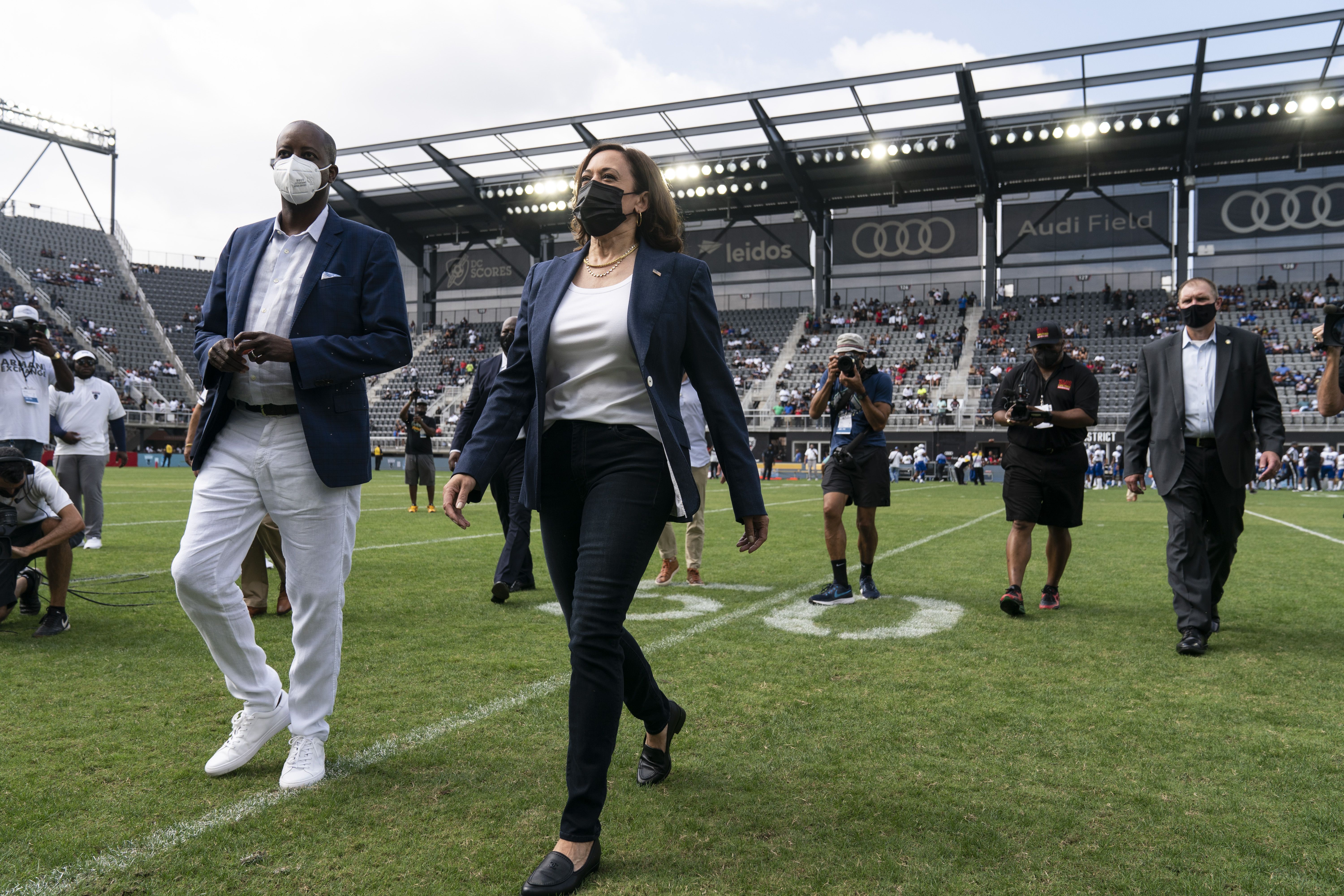 Vice President Kamala Harris, center, departs with Wayne A. I. Frederick, president of Howard University, left, after flipping a coin ahead of the Howard University and Hampton University football gam