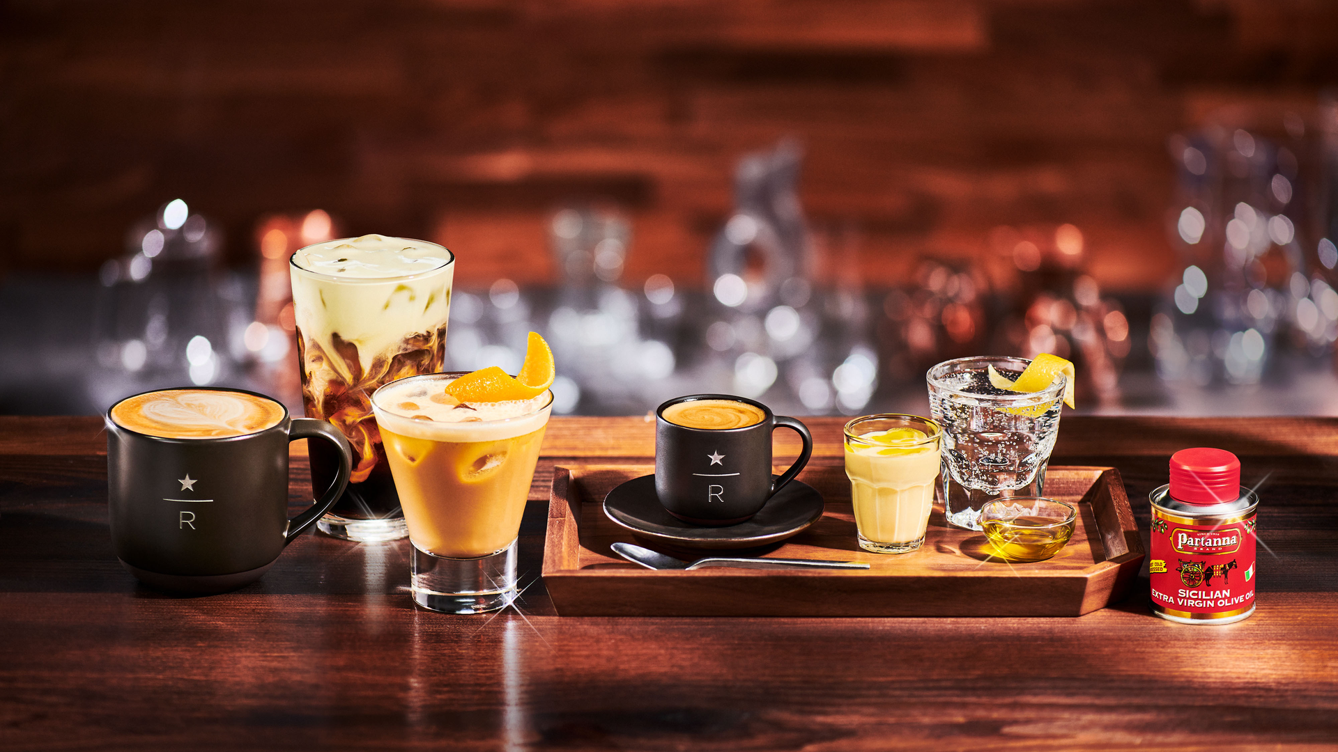 A row of different kinds of coffee drinks on a wooden bar or table.