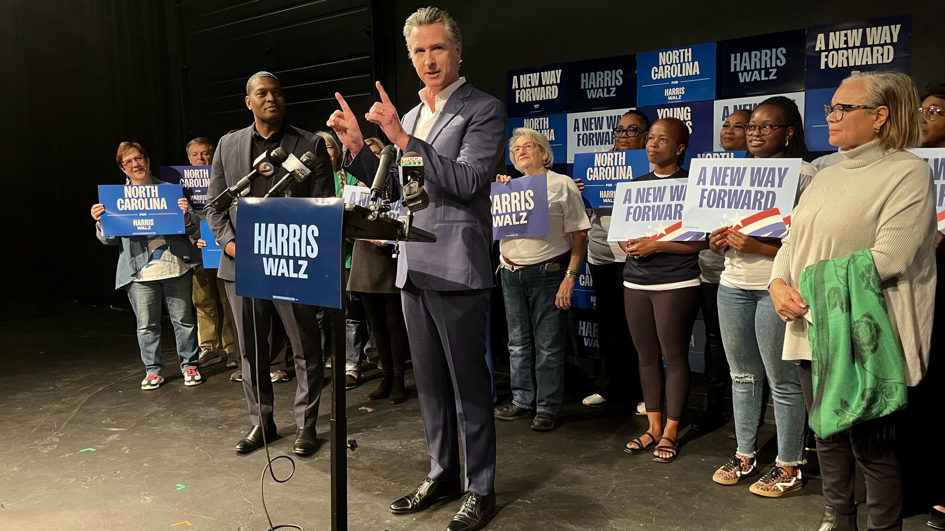 Gov. Gavin Newsom speaks at a podium with Harris supporters