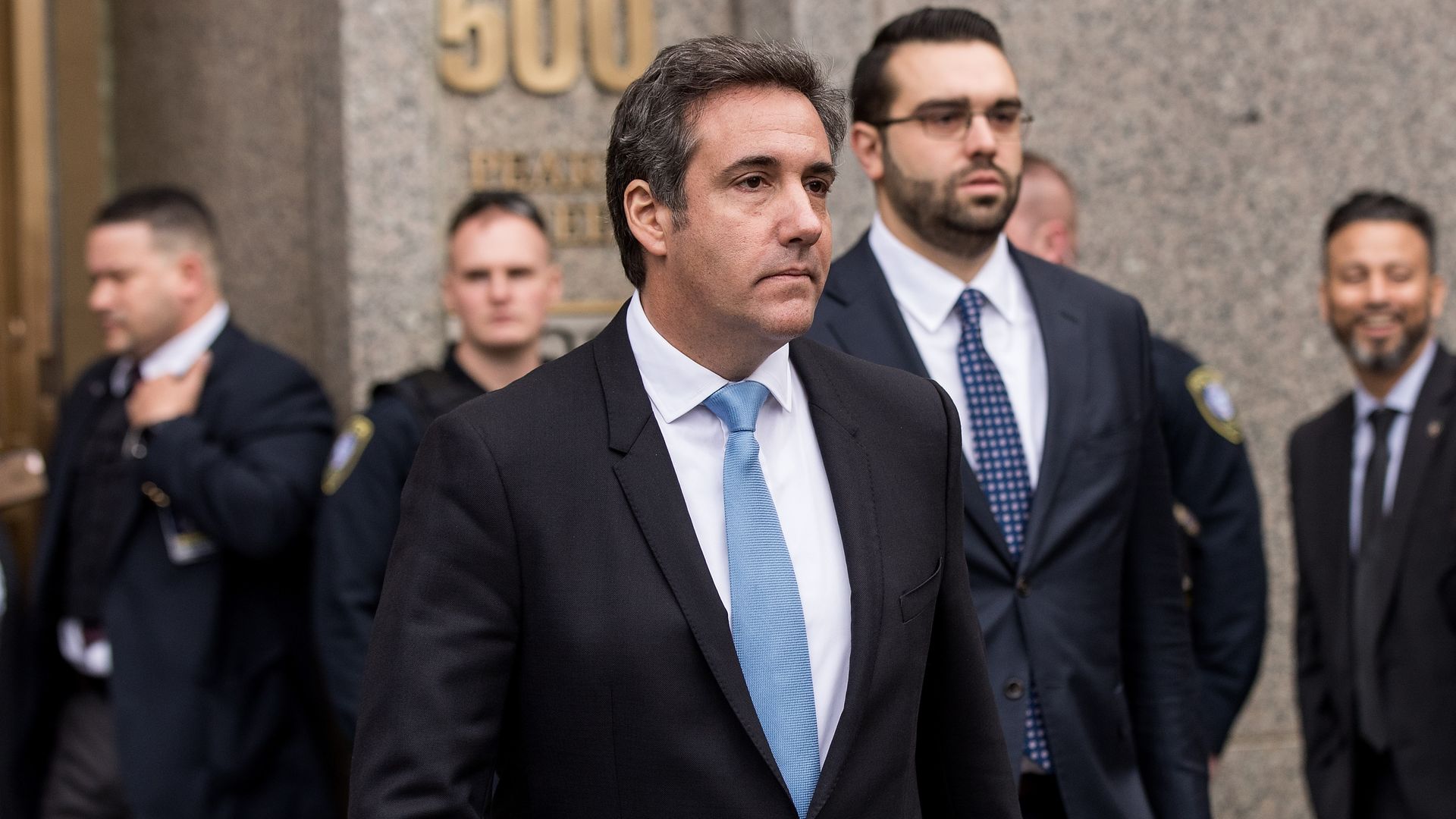 Michael Cohen, longtime personal lawyer for President Donald Trump, walks out of a building frowning