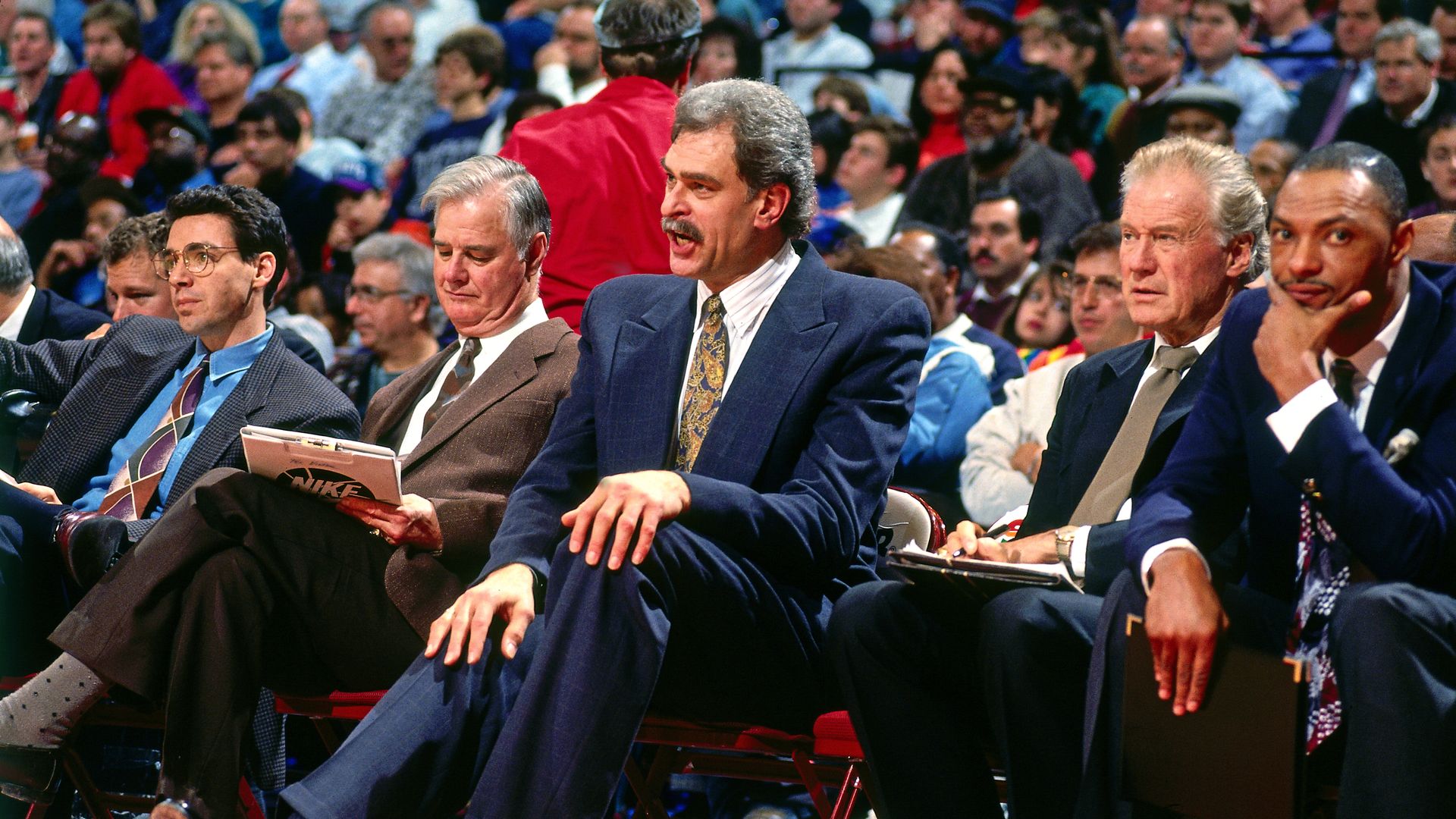 A row of basketball coaches with Phil Jackson at the center.