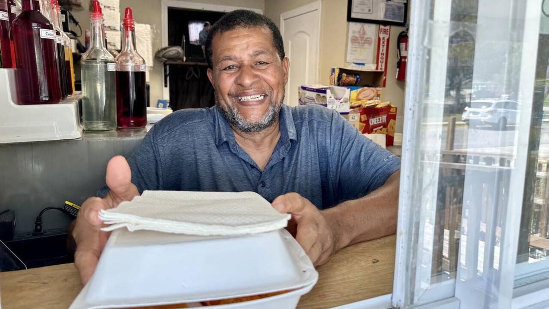 Photo shows owner Conrad Bailey in the window of North Roman Street Snowballs