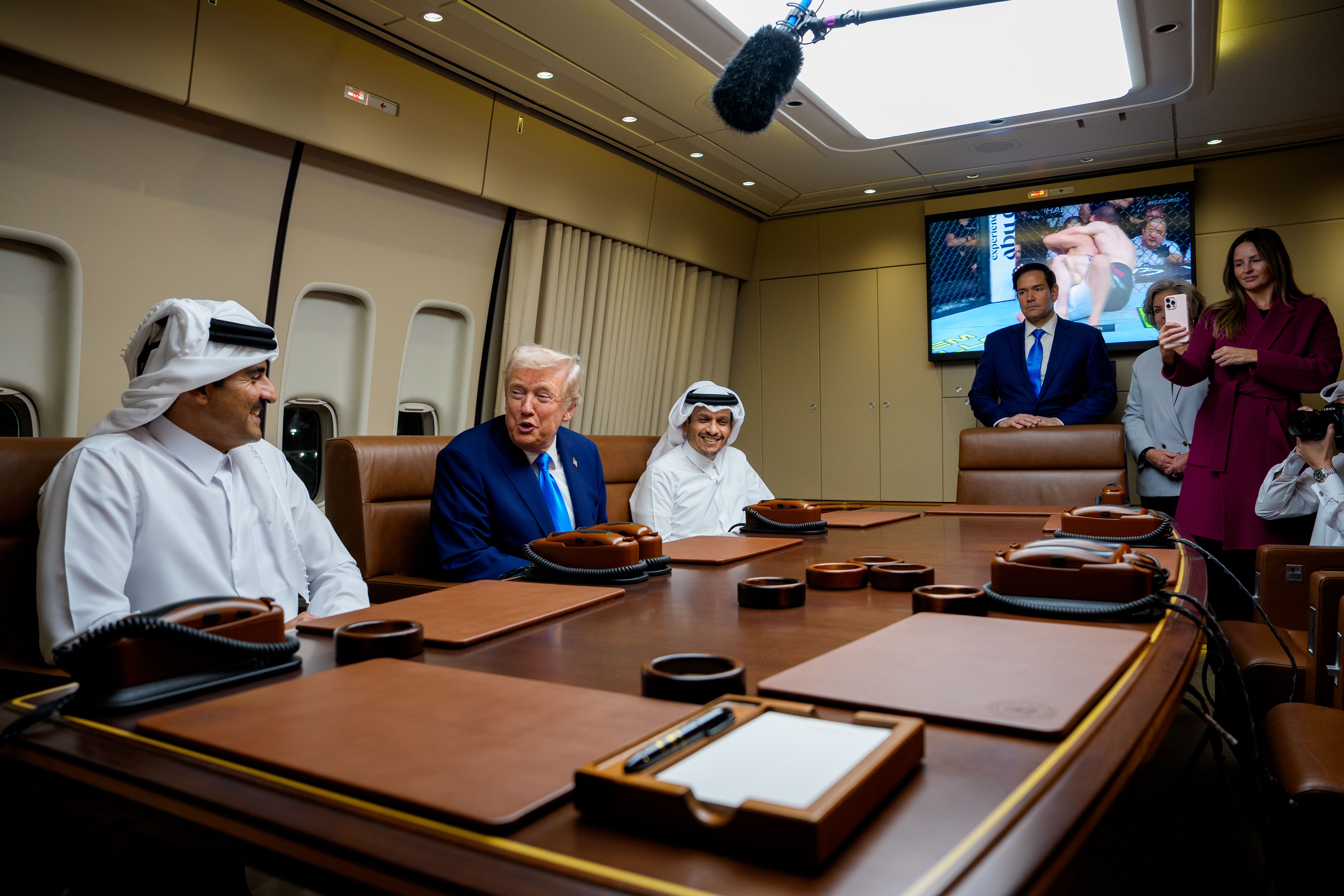 U.S. President Donald Trump welcomes Emir of Qatar Sheikh Tamim ibn Hamad Al Thani (L) and Prime Minister of Qatar Mohammed bin Abdulrahman bin Jassim bin Jaber Al Thani (3rd-L) aboard Air Force One during a refueling stop at Al-Udeid Air Base on October 25, 2025 in Abu Nakhlah, Qatar. Trump is trav