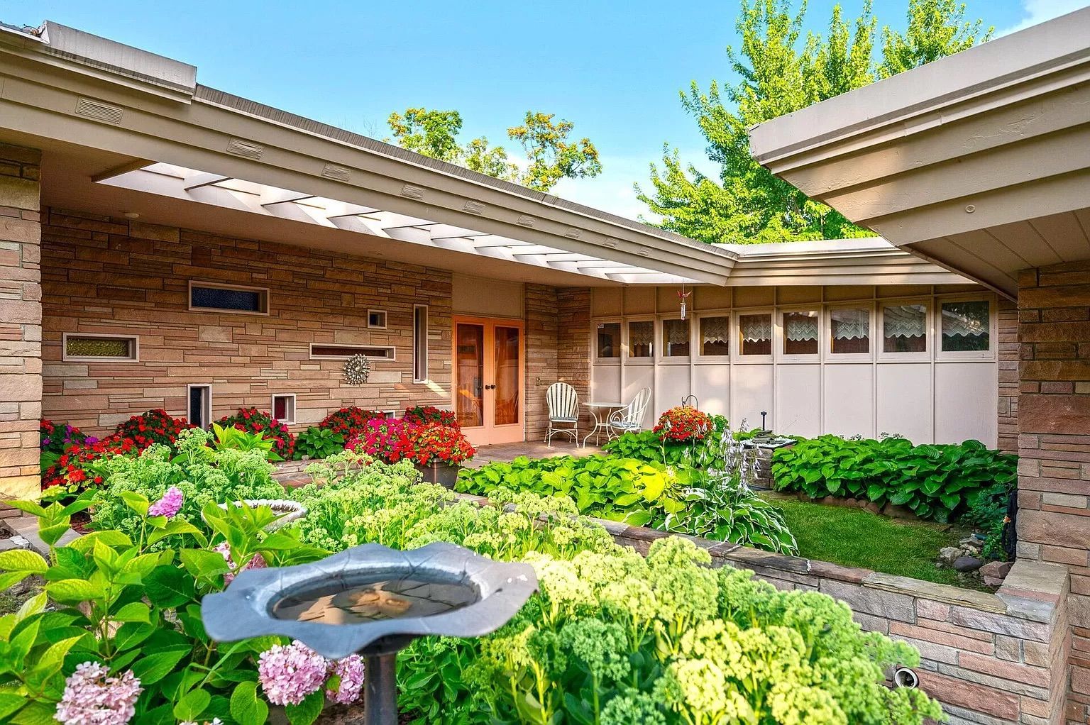 A terrace with green grass and hydrangea bushes.