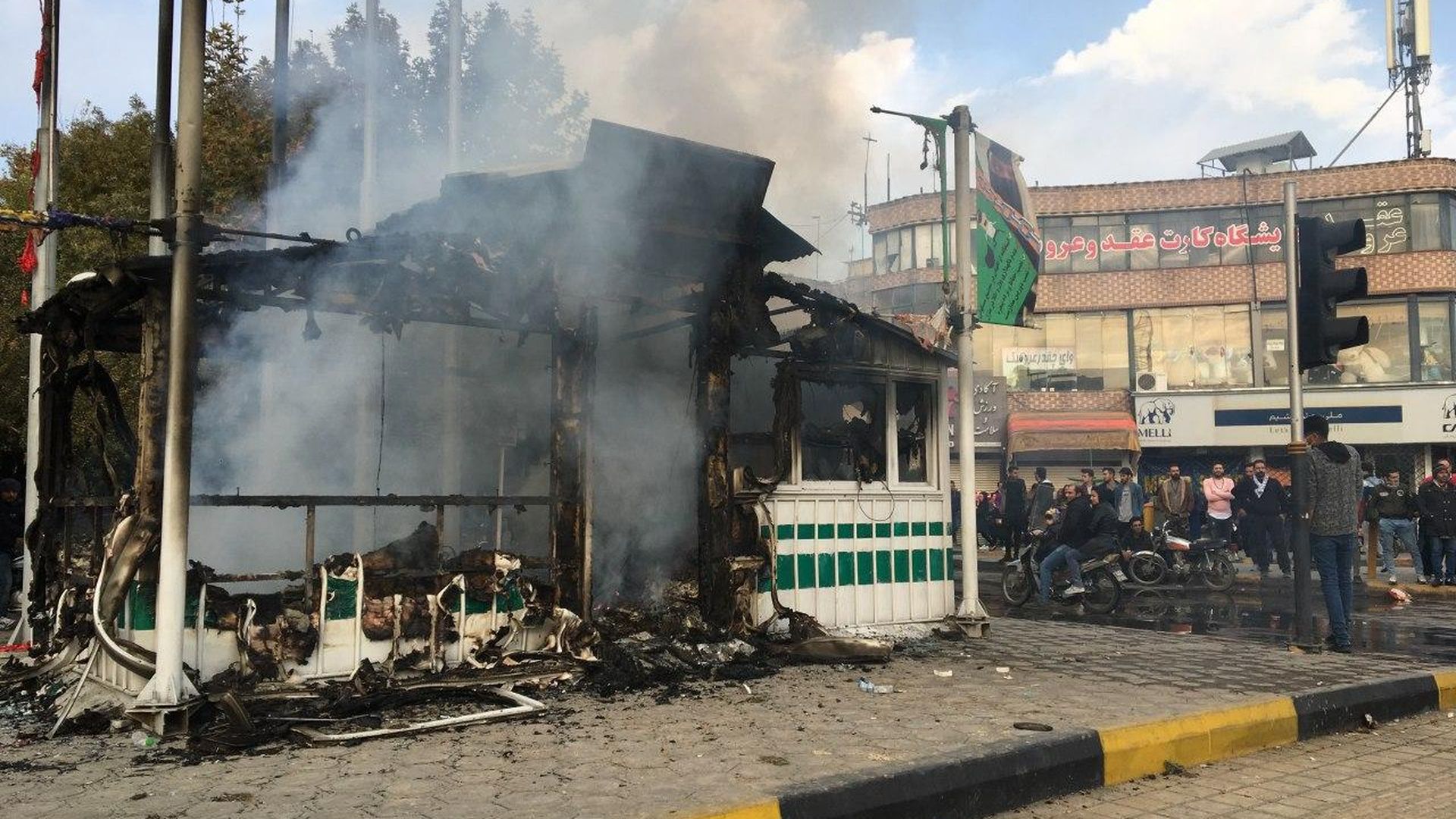 Iranians gather around a charred police station while they protest