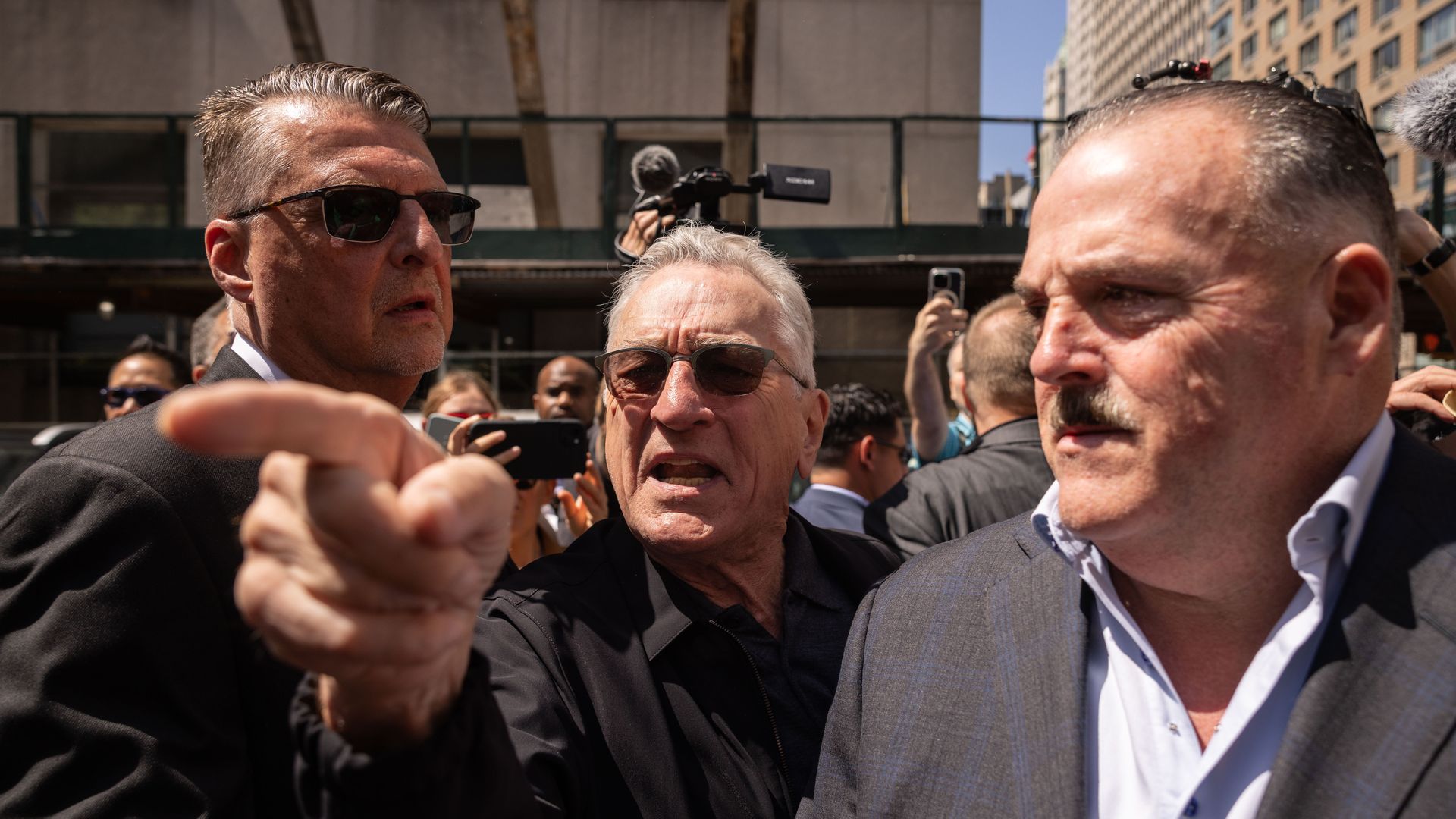 Actor Robert DeNiro points a finger as he argues with a Trump supporter.