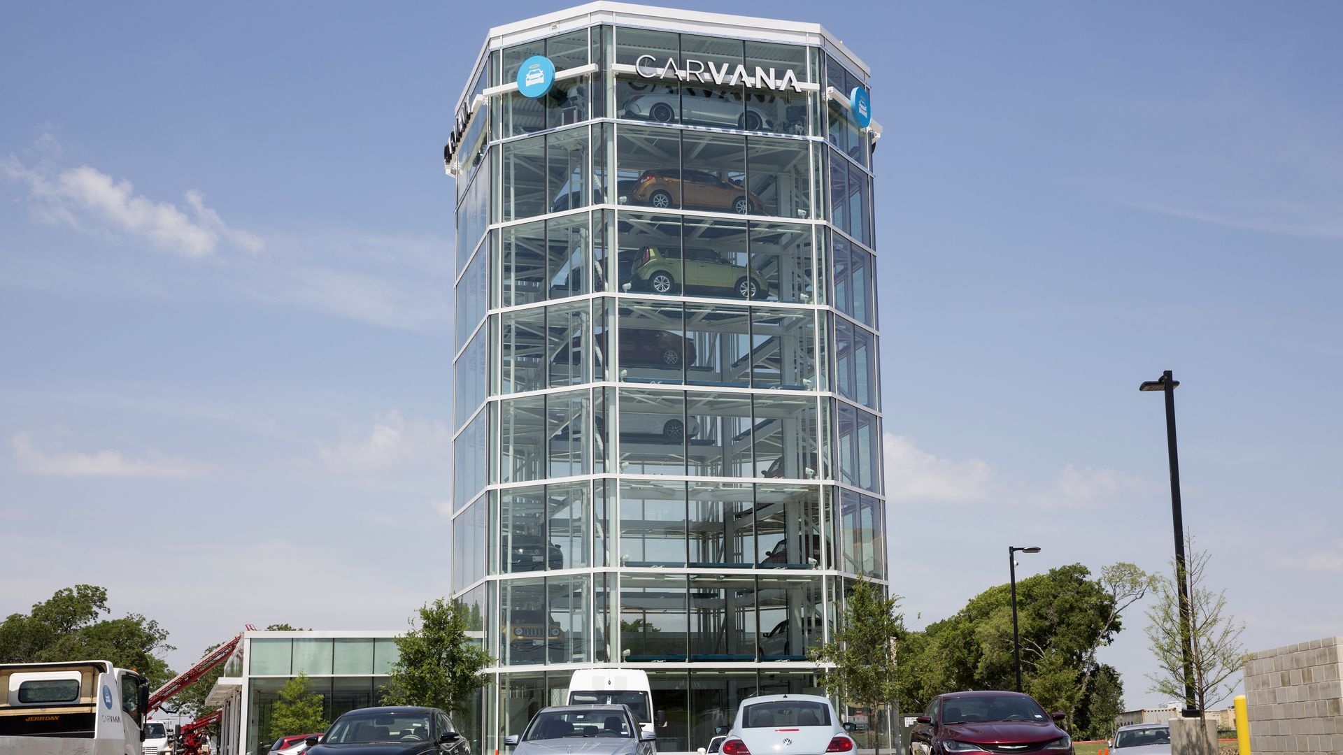 A tall glass building full of cars