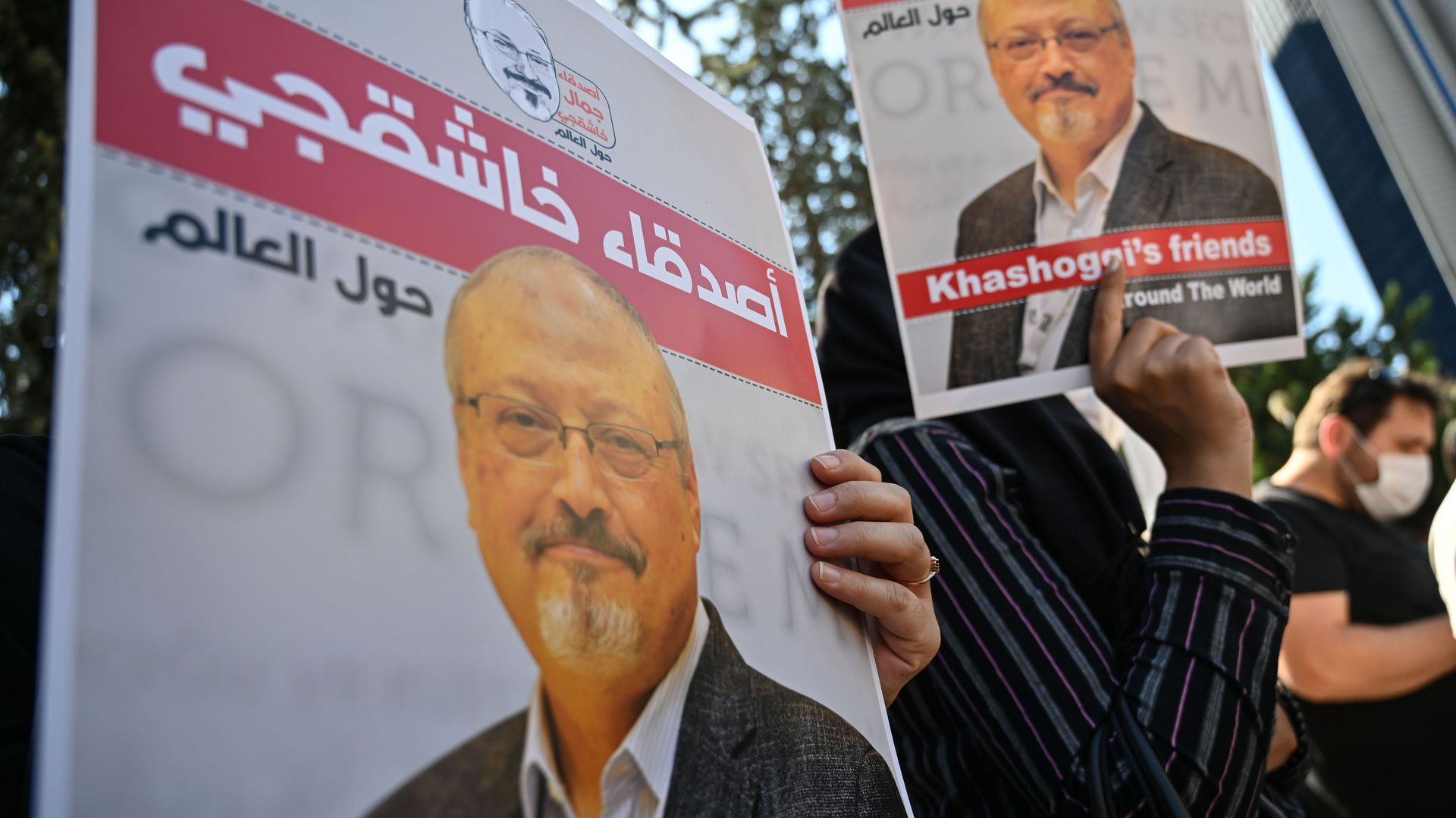 People holding signs with Jamal Khashoggi's face on them in Istanbul in October 2020.