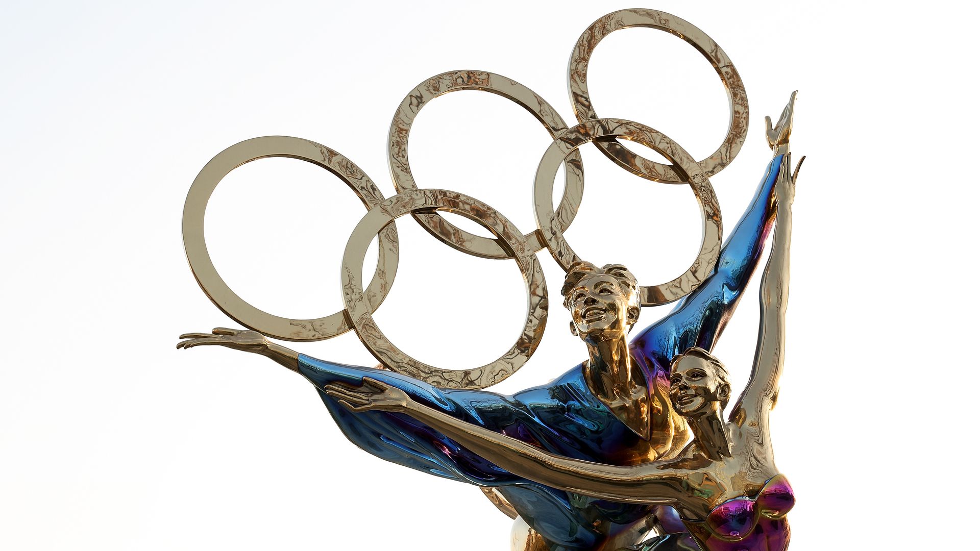 A sculpture of olympians with the olympics logo.