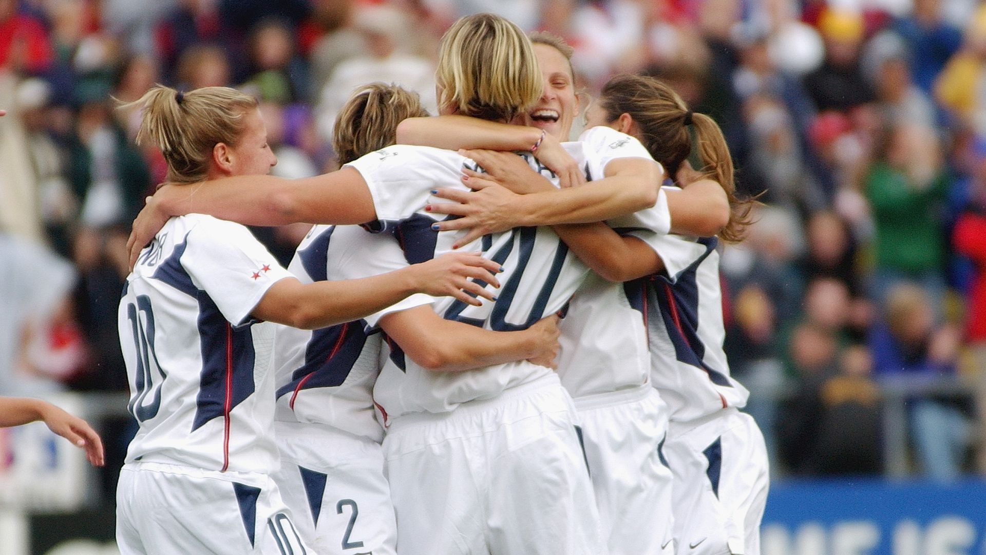 Players from the U.S. Women's National Soccer Team hug in a huddle after scoring a goal
