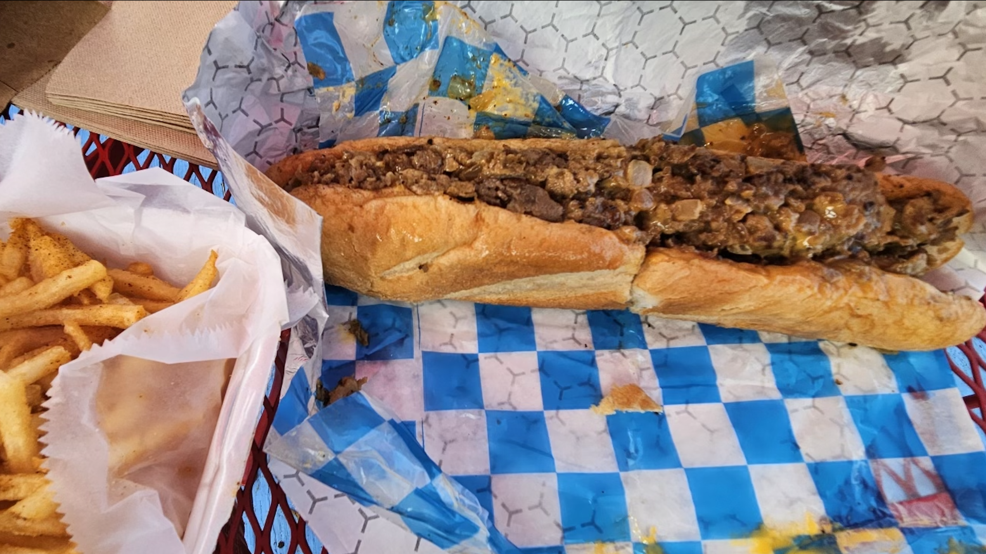 A philly cheesesteak with fries.