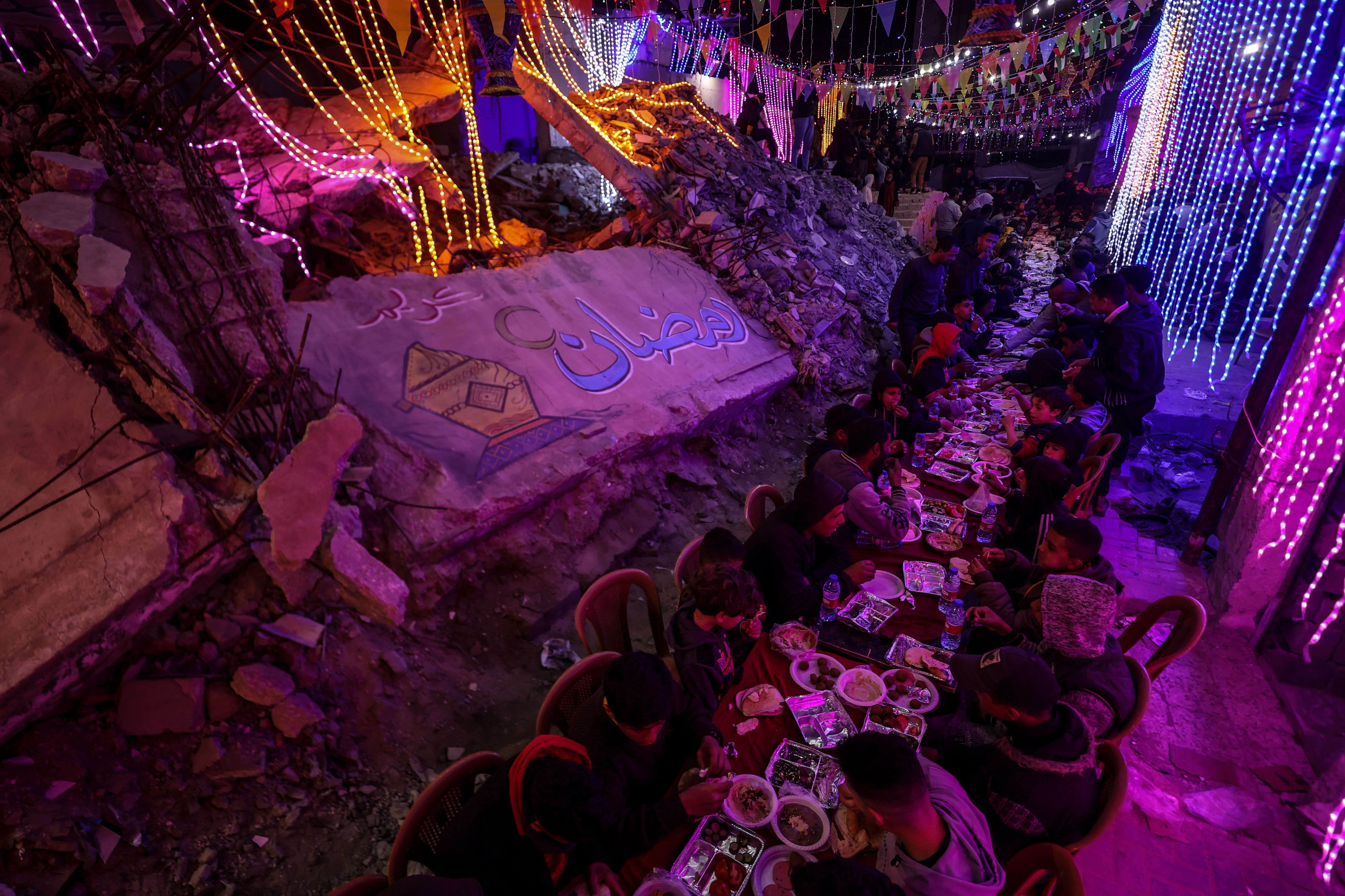 Palestinians are having first sahur (pre-dawn) meal of the holy month of Ramadan under the lights they hung among the buildings and houses that were heavily damaged and some of them were completely destroyed in the Israeli army's attacks on Gaza on February 28