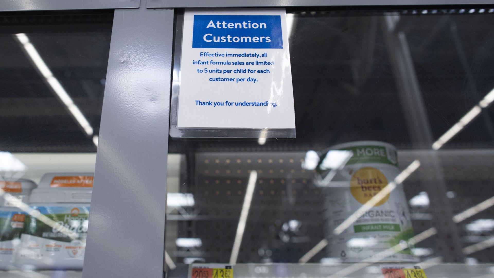 A glass case with mostly empty shelves and a warning on it