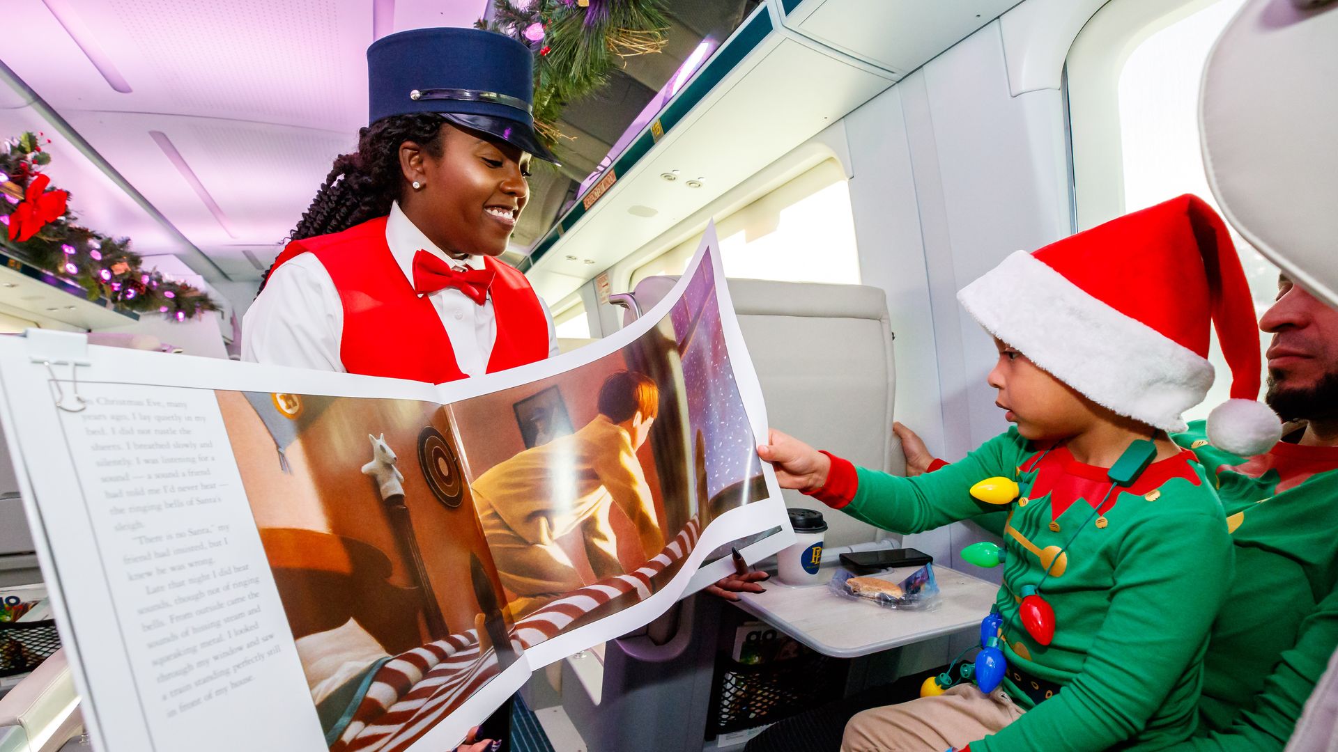 A train employee reads to a child during a reenactment of the "Polar Express" on the Brightline.