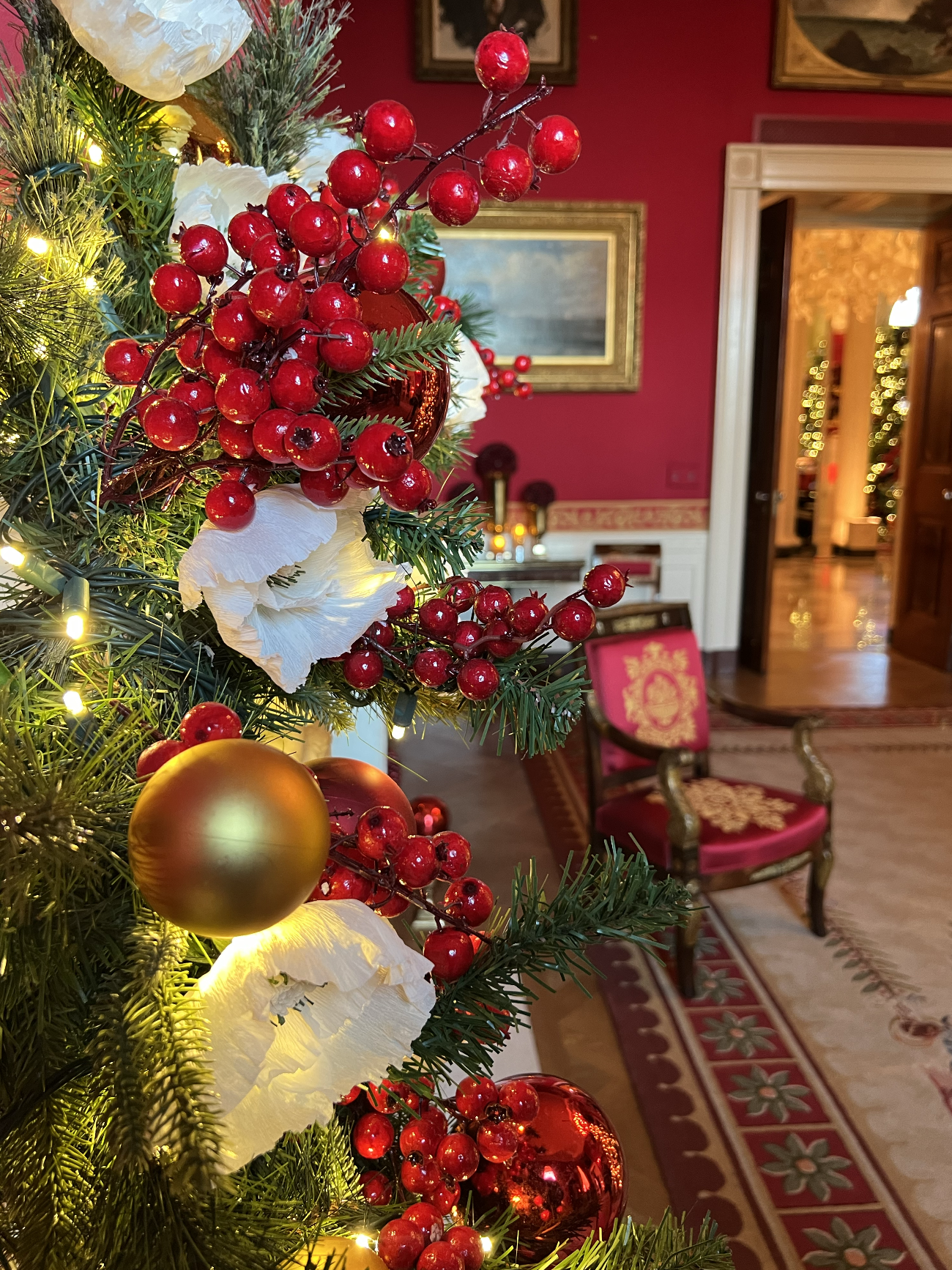 A close up of flowers and ornaments on the Red Room mantle. 