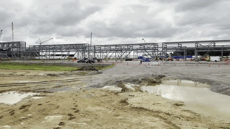 Steel trusses, viewed from across a construction site.