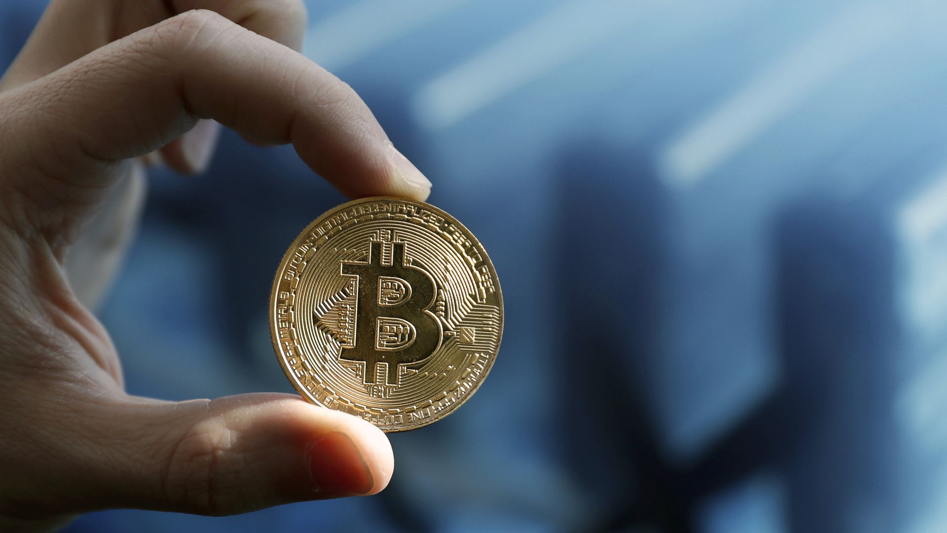 A hand holding Bitcoin.