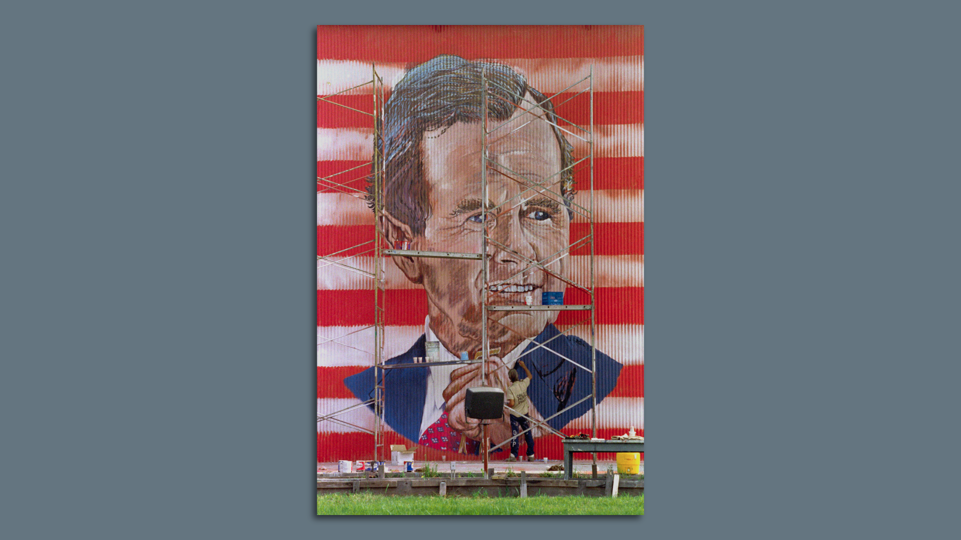 Photo shows an inmate in New Orleans painting a portrait of George H. W. Bush on a wall.