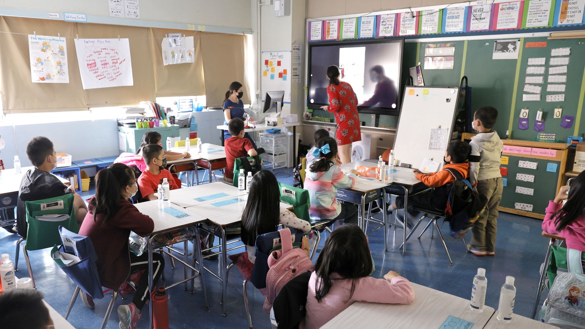 Co-teachers at Yung Wing School P.S. 124 Marisa Wiezel (who is related to the photographer) and Caitlin Kenny give a lesson to their masked students.