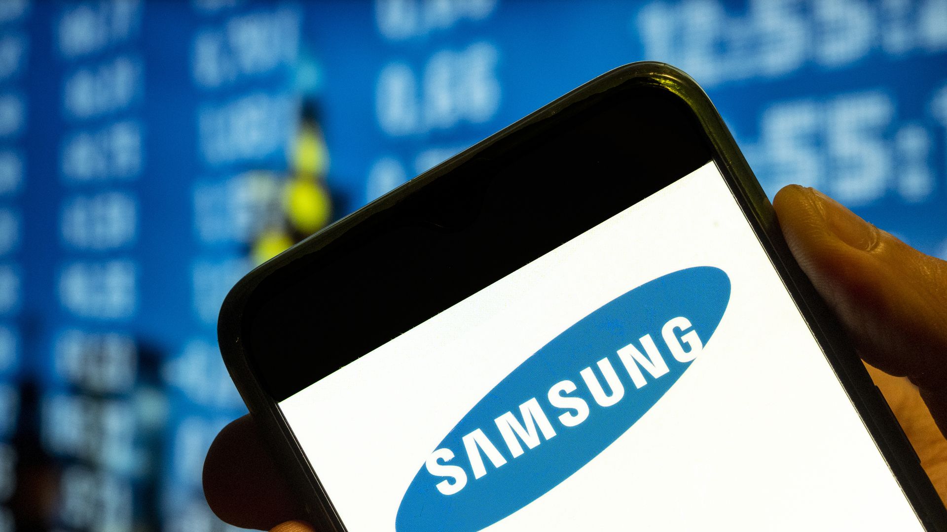 Image of a person holding a phone with the Samsung logo
