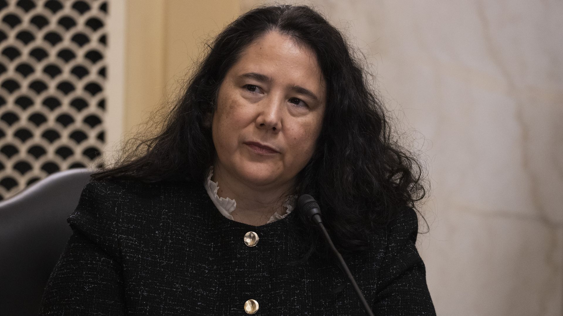 In this image, Isabel Guzman speaks in front of a microphone 