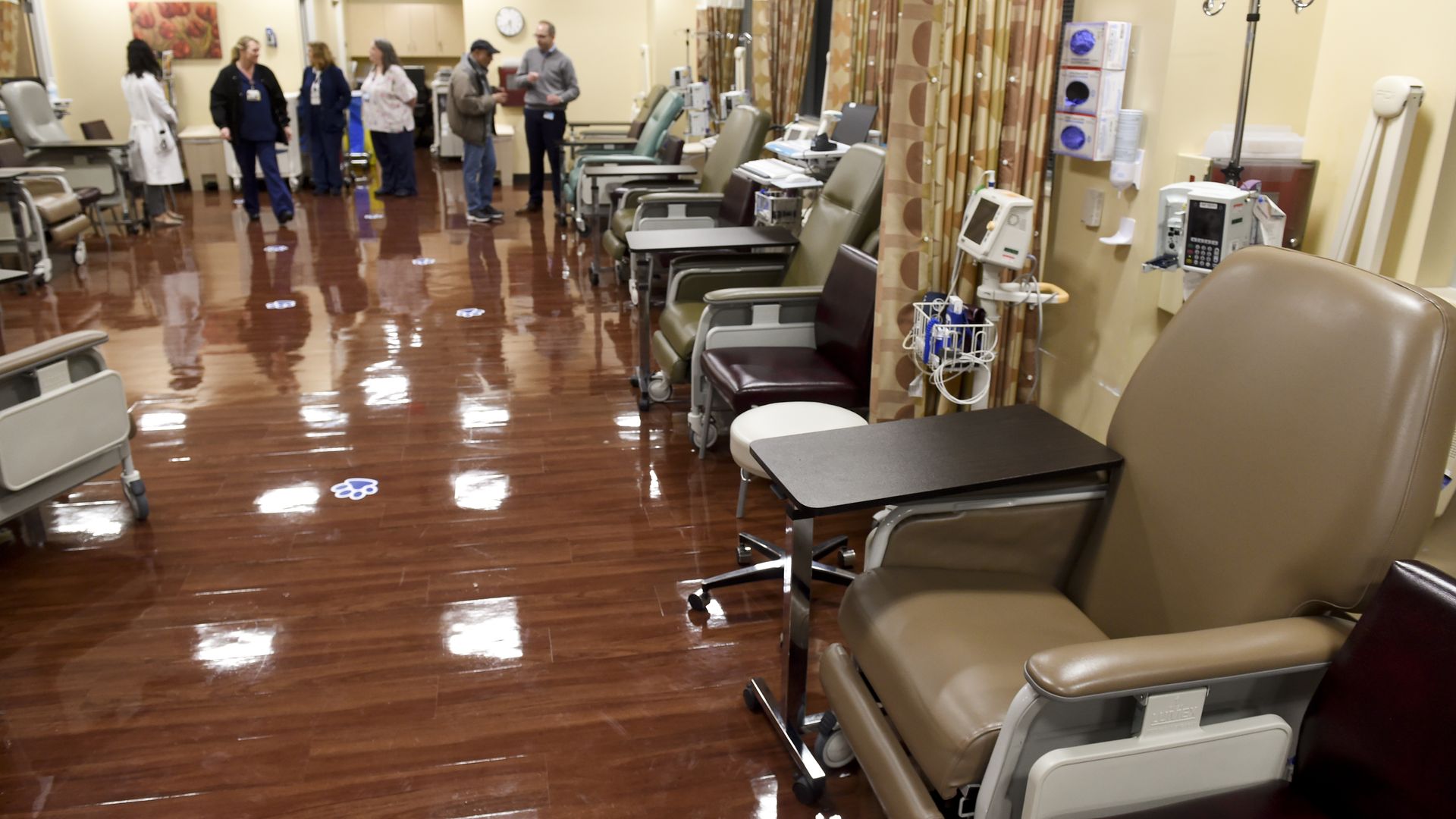 An infusion center with chairs, IVs, and curtains.