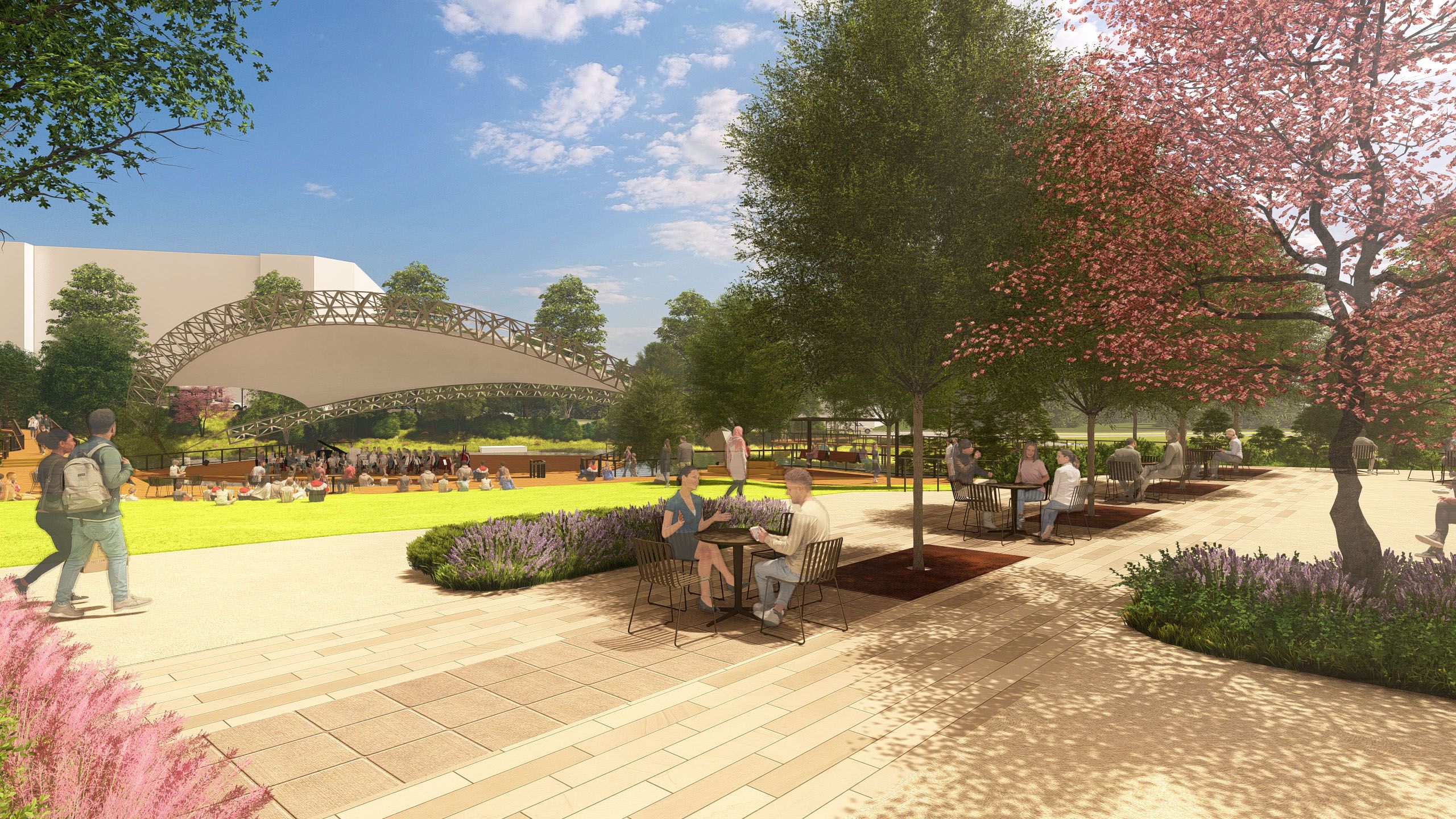 Park scene with people sitting at tables under trees with pink and green foliage, a grass area with an audience near a stage covered by a unique curved structure, and a blue sky with clouds.