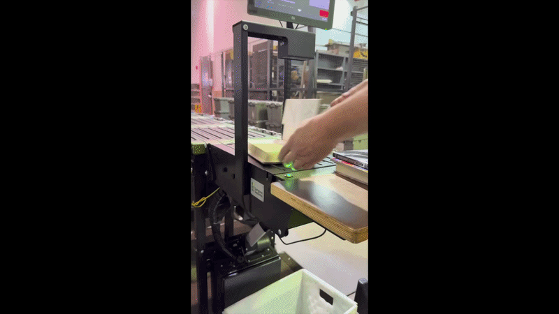 A machine sorts and process books along a conveyor belt and drops them into bins.