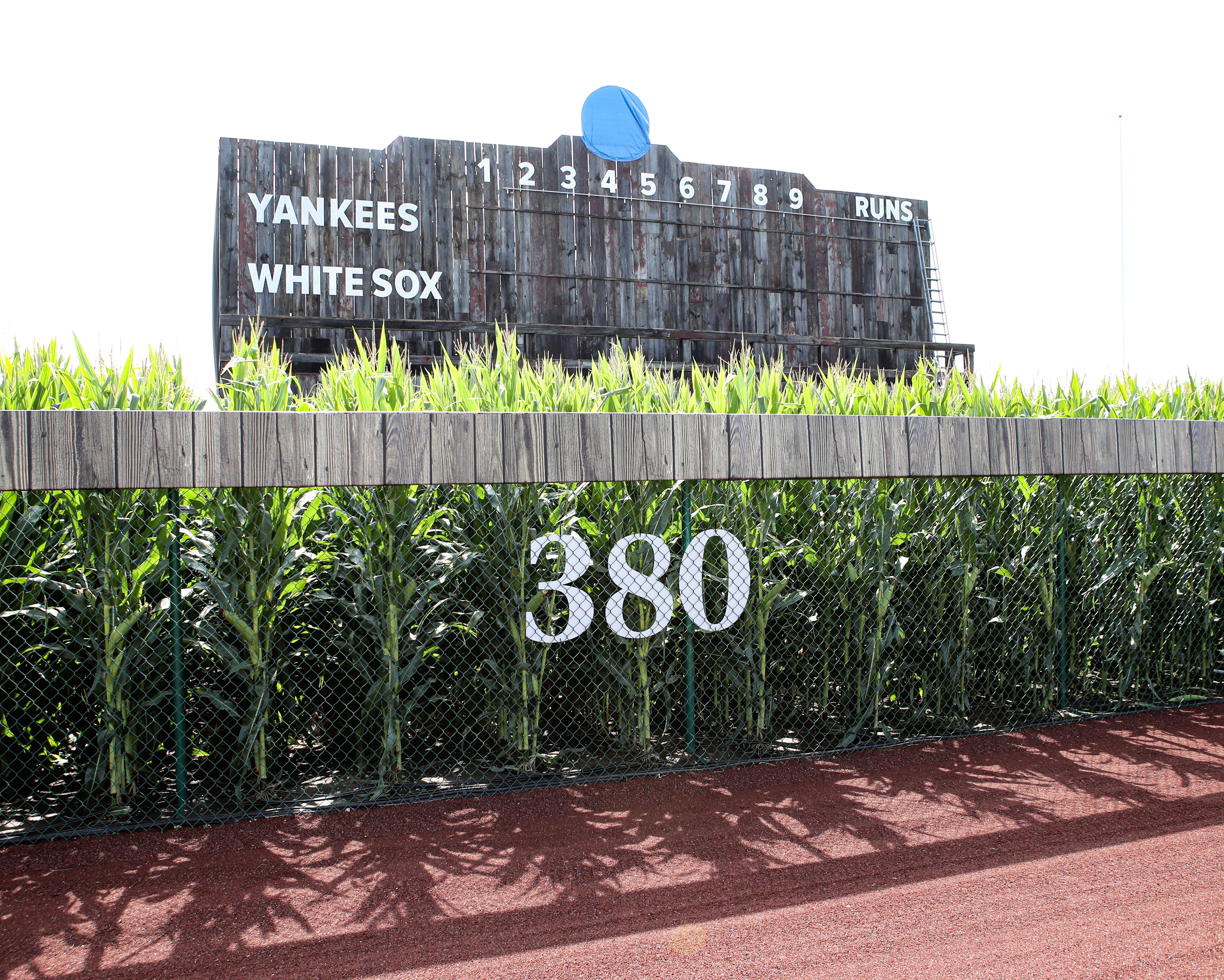The outfield wall of the Field of Dreams in Dyersville, Iowa with a wooden scoreboard in the background