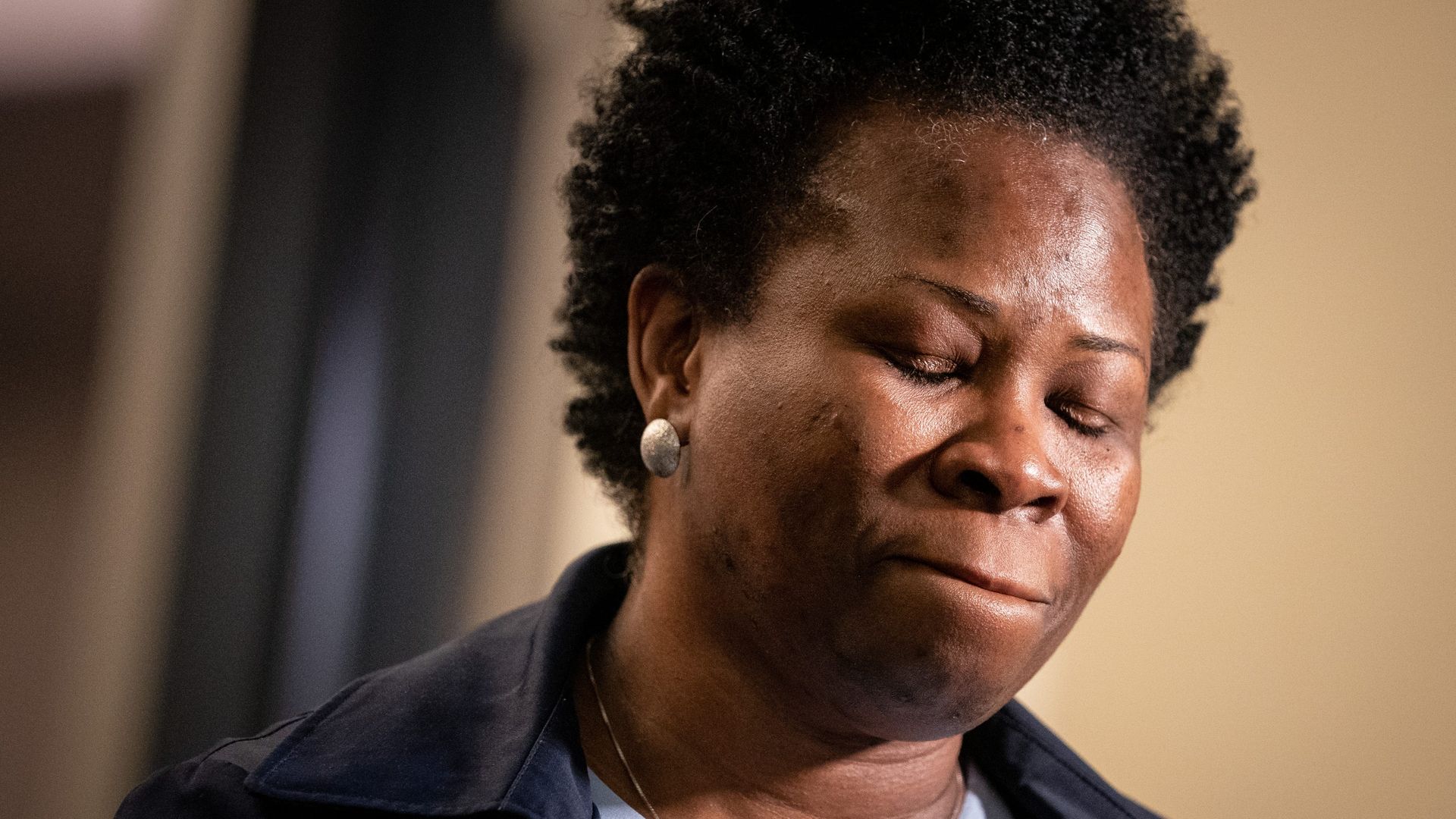 Shaundelle Brooks stands in a courtoom hallway with her eyes closed.