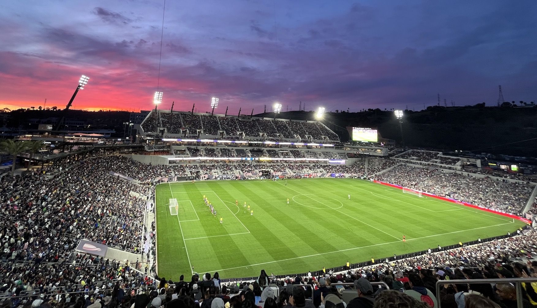 A sunset behind a soccer stadium