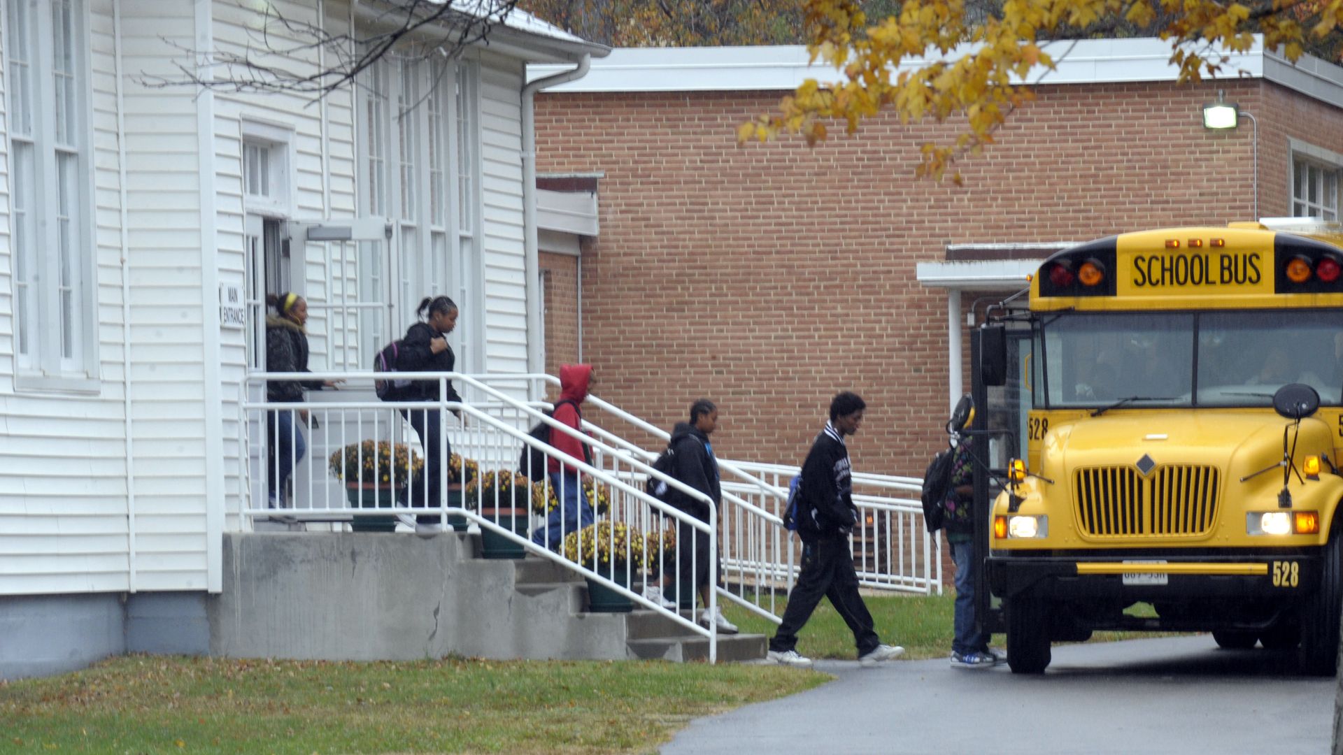 Kids board a yellow school bus