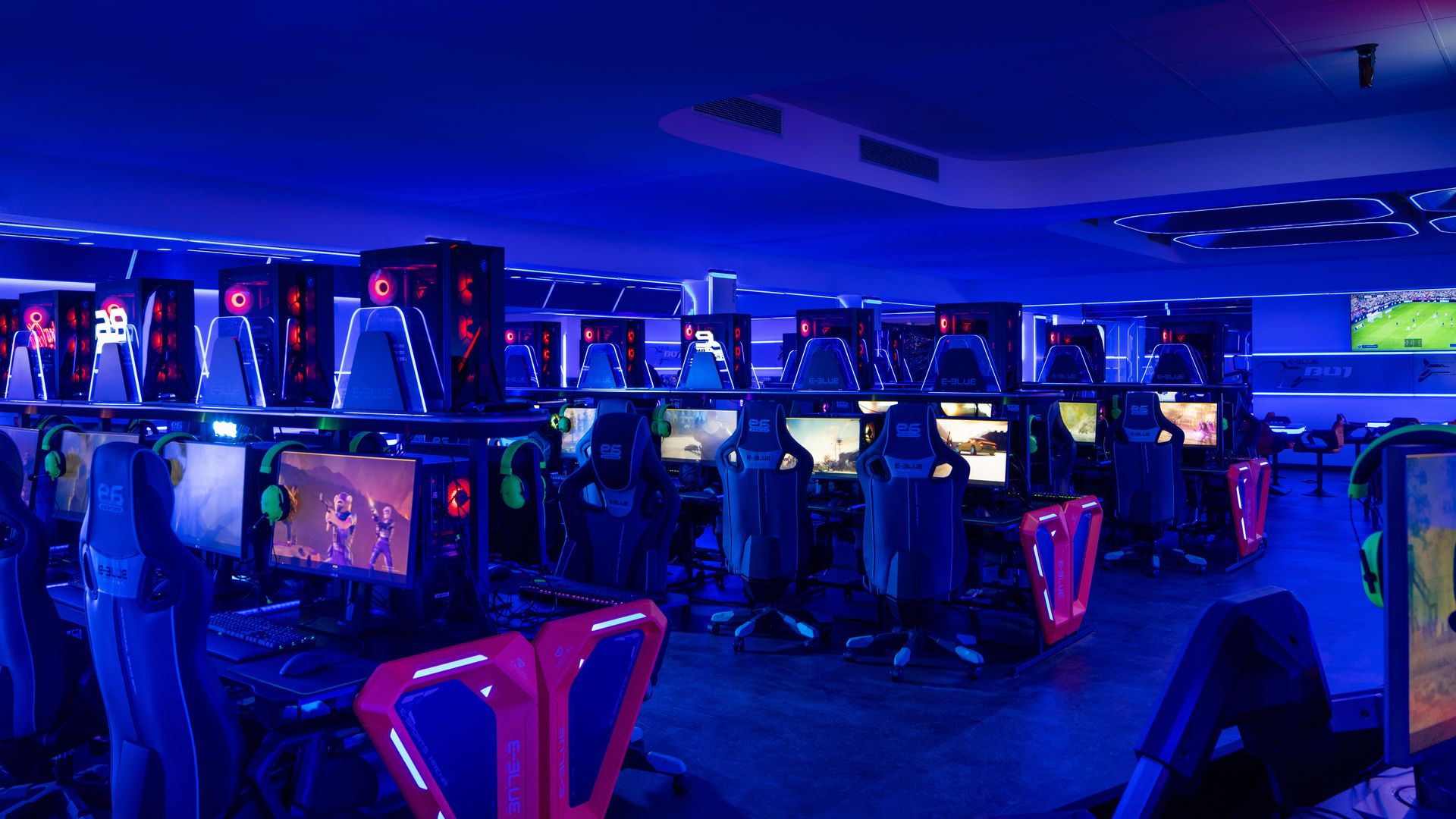 Rows of gaming PCs under a blue light. 