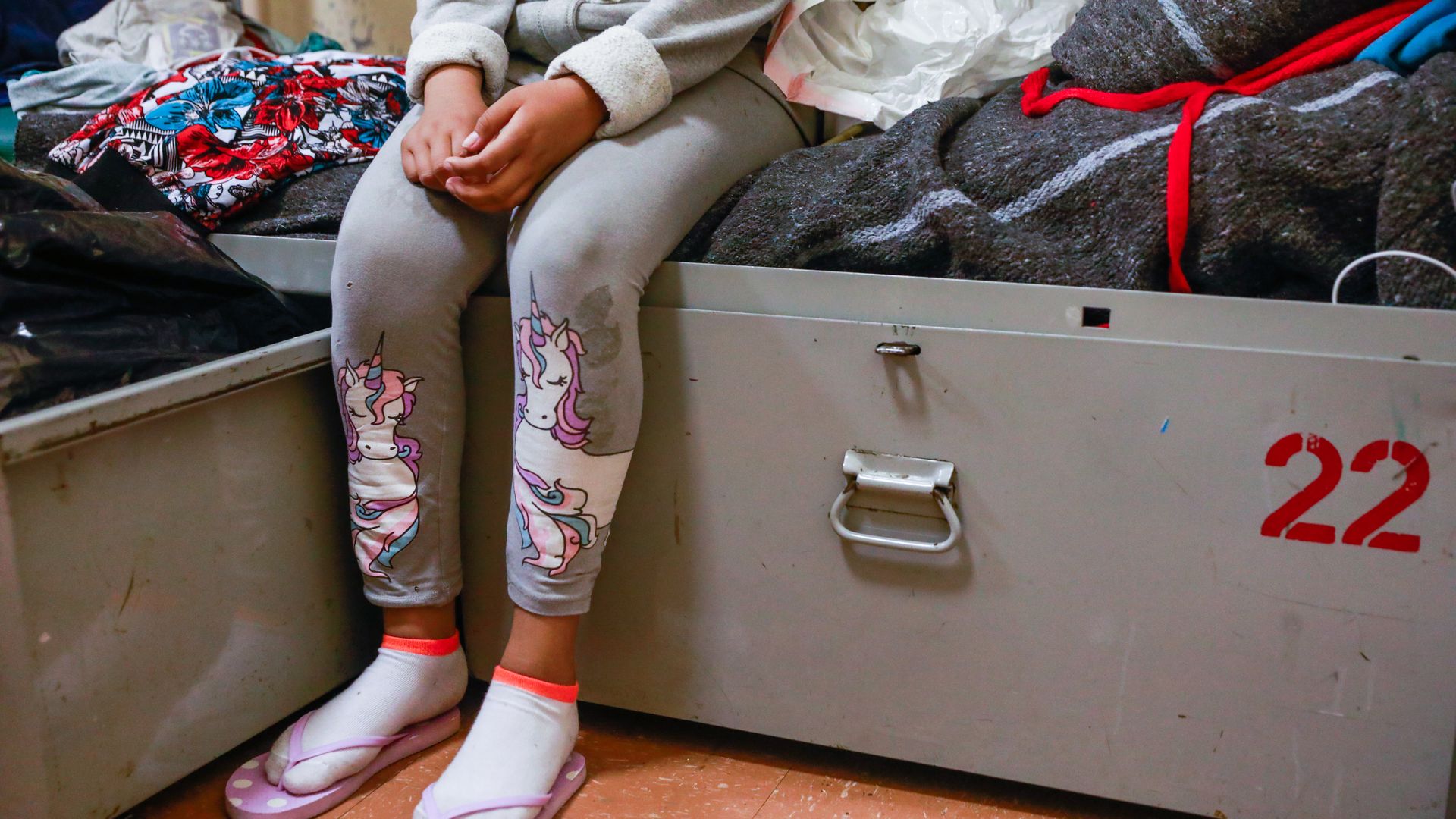 Photo of a girl sitting at a shelter bed