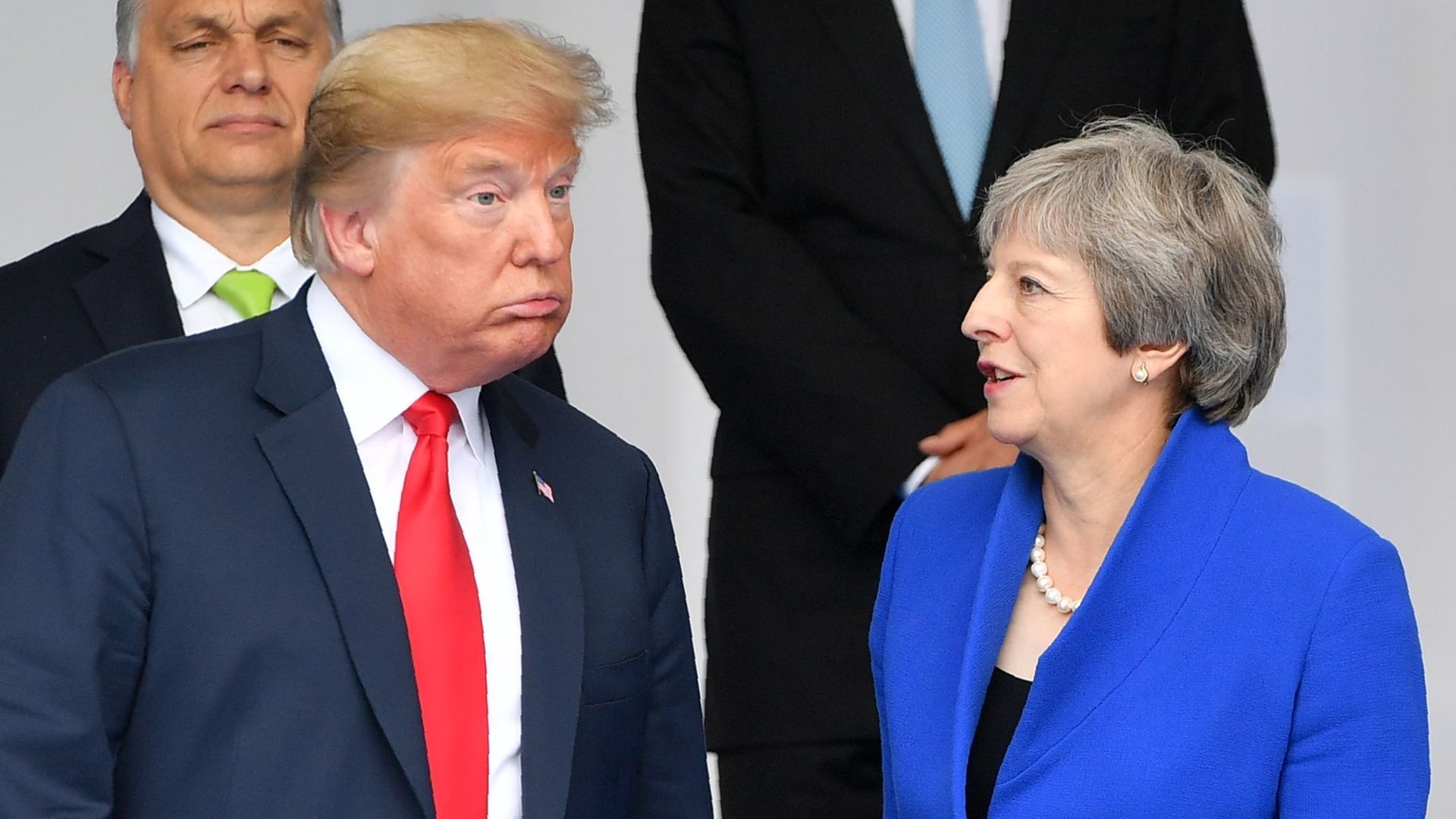 President Donald Trump (L) gestures as he poses alongside Britain's Prime Minister Theresa May (C) and Iceland's Prime Minister Katrín Jakobsdóttir (R) during the opening ceremony of the NATO summit.