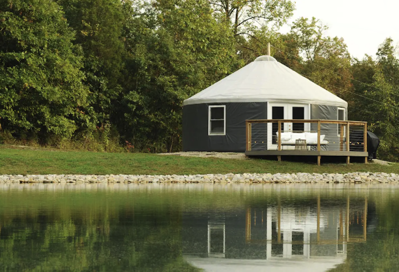 A yurt with a deck sits on a private pond.
