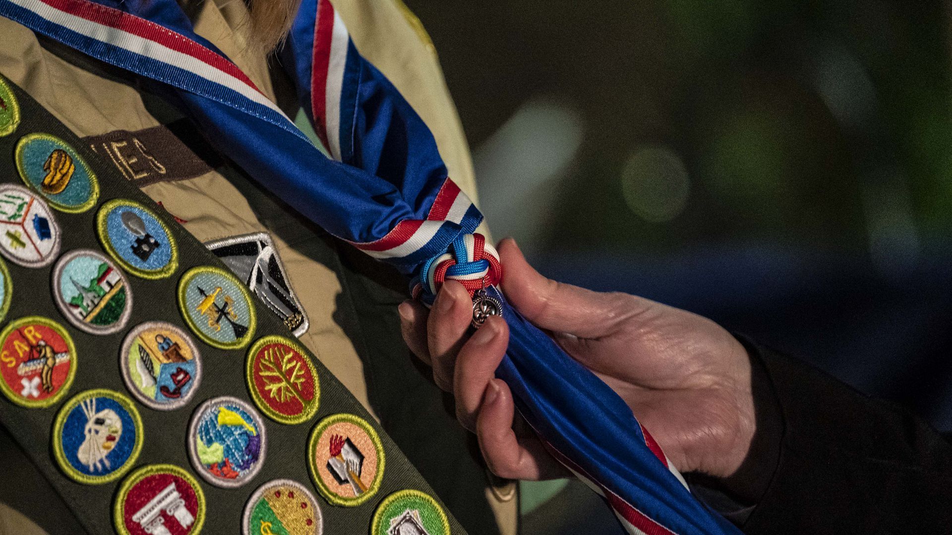 A photo a scout receiving a blue Eagle Scout neckerchief during a ceremony.