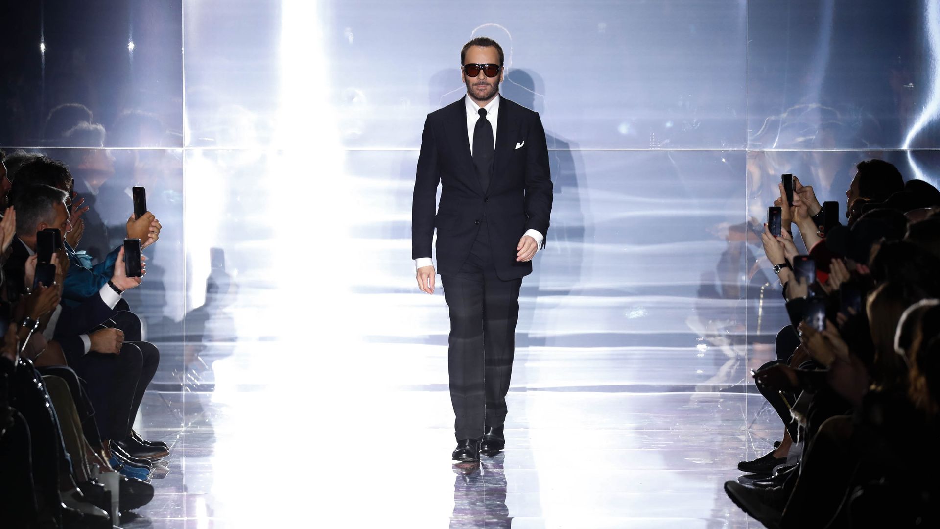 The fashion designer Tom Ford walks down a runway following a fashion show.