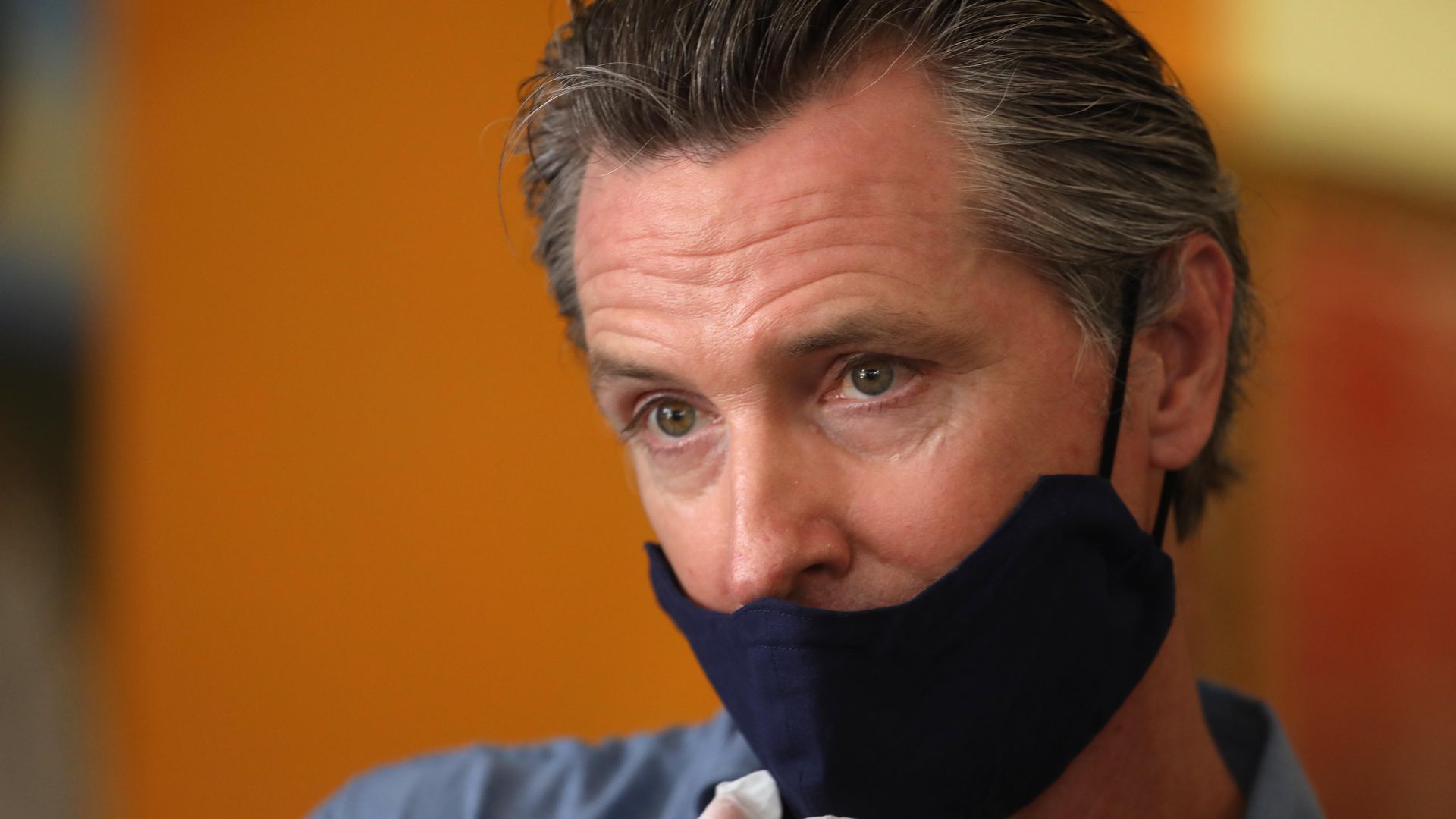 Gavin Newsom wears a mask and gloves