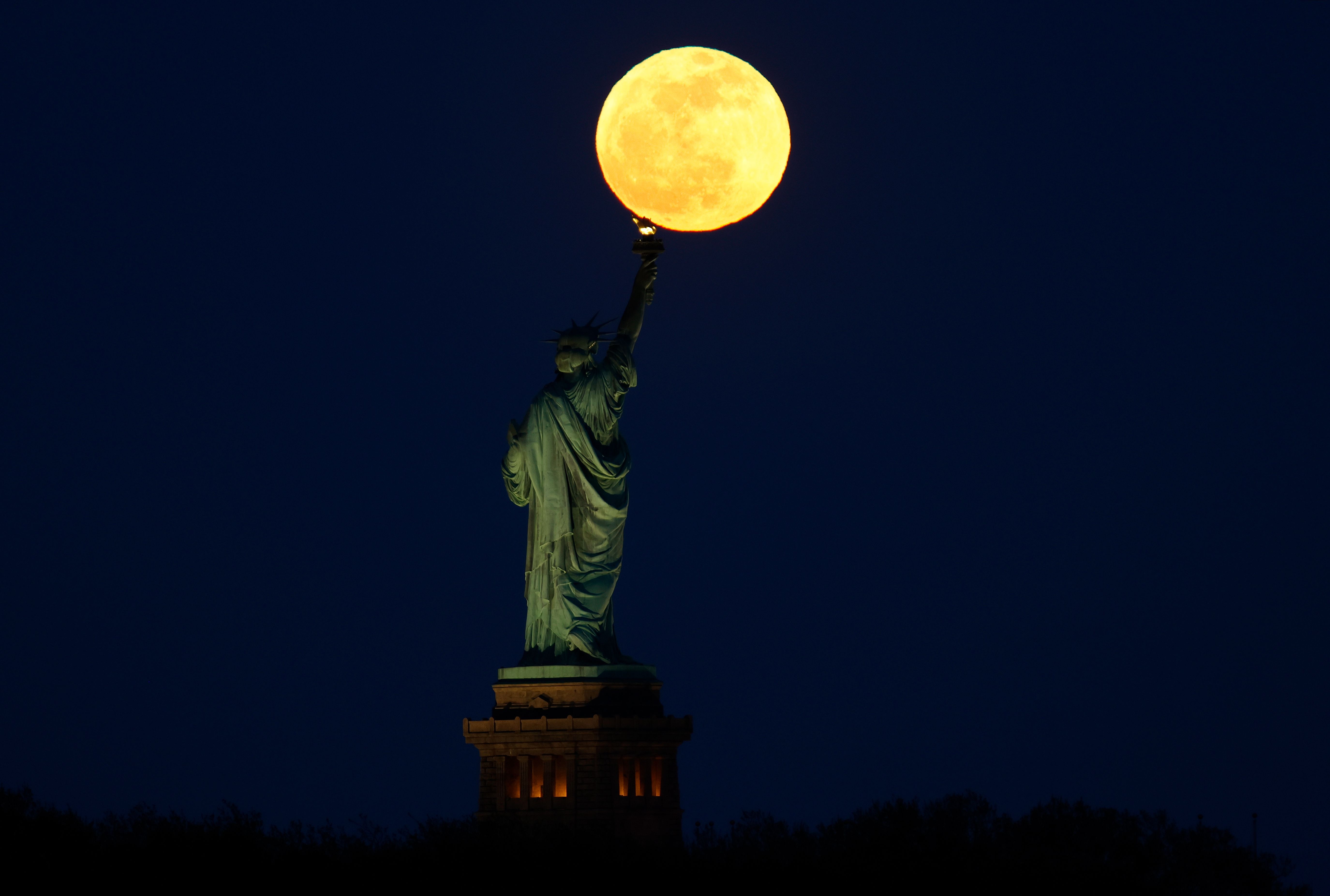 Moon behind Statue of Liberty