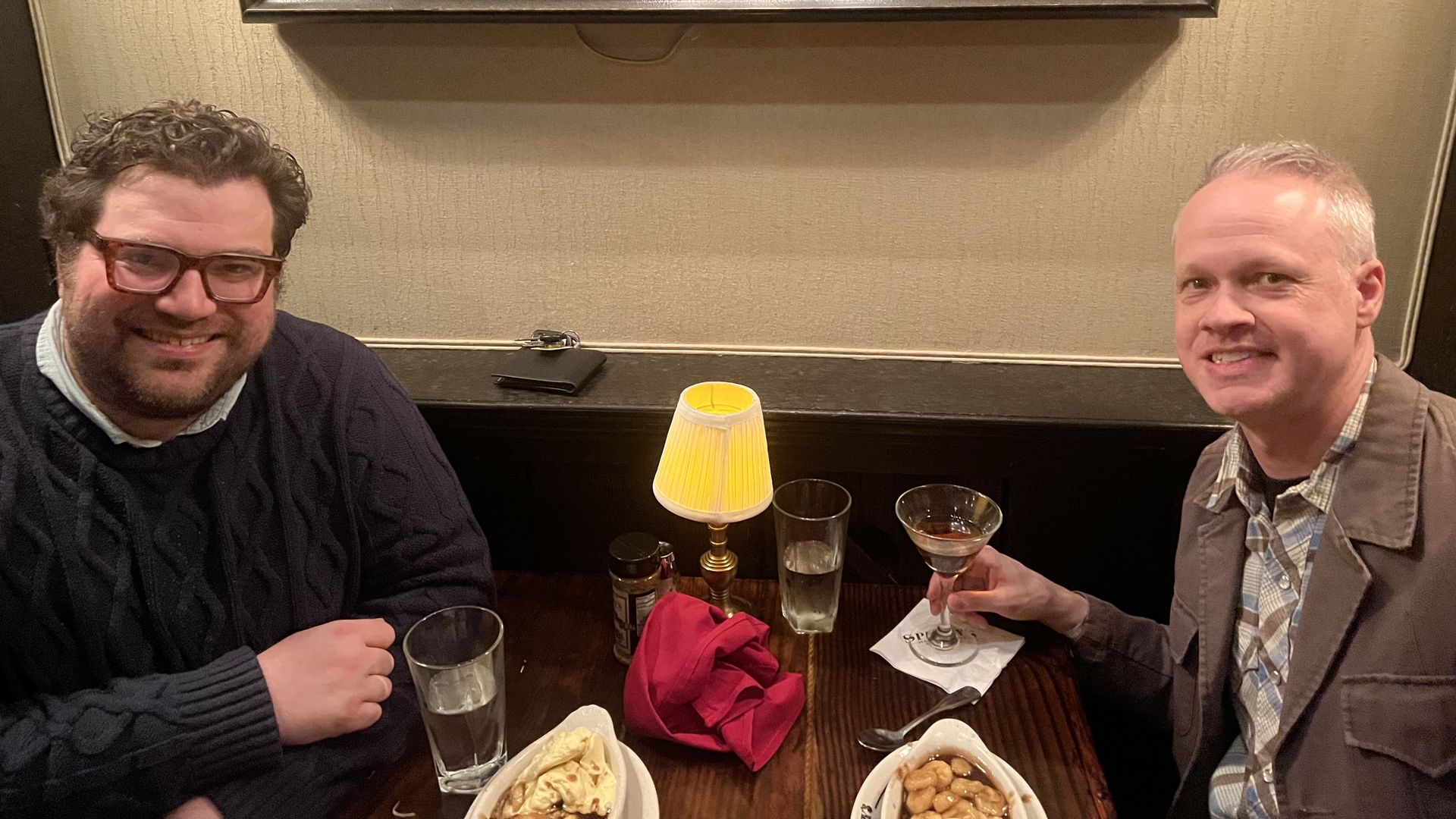 Adam and Nate smiling at a restaurant table.