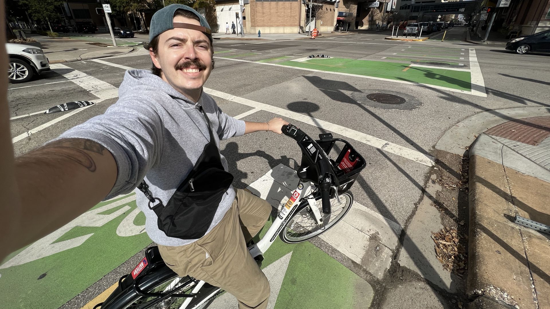 Axios Houston reporter Jay R. Jordan takes a selfie while riding a BCycle e-bike in downtown Houston 