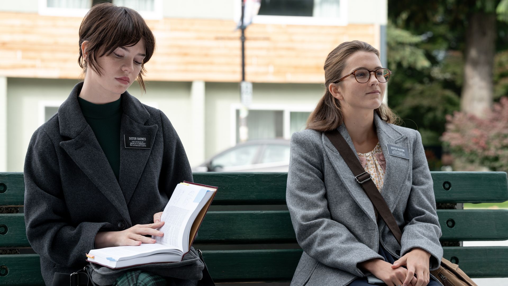 Two actors sit on a bench.