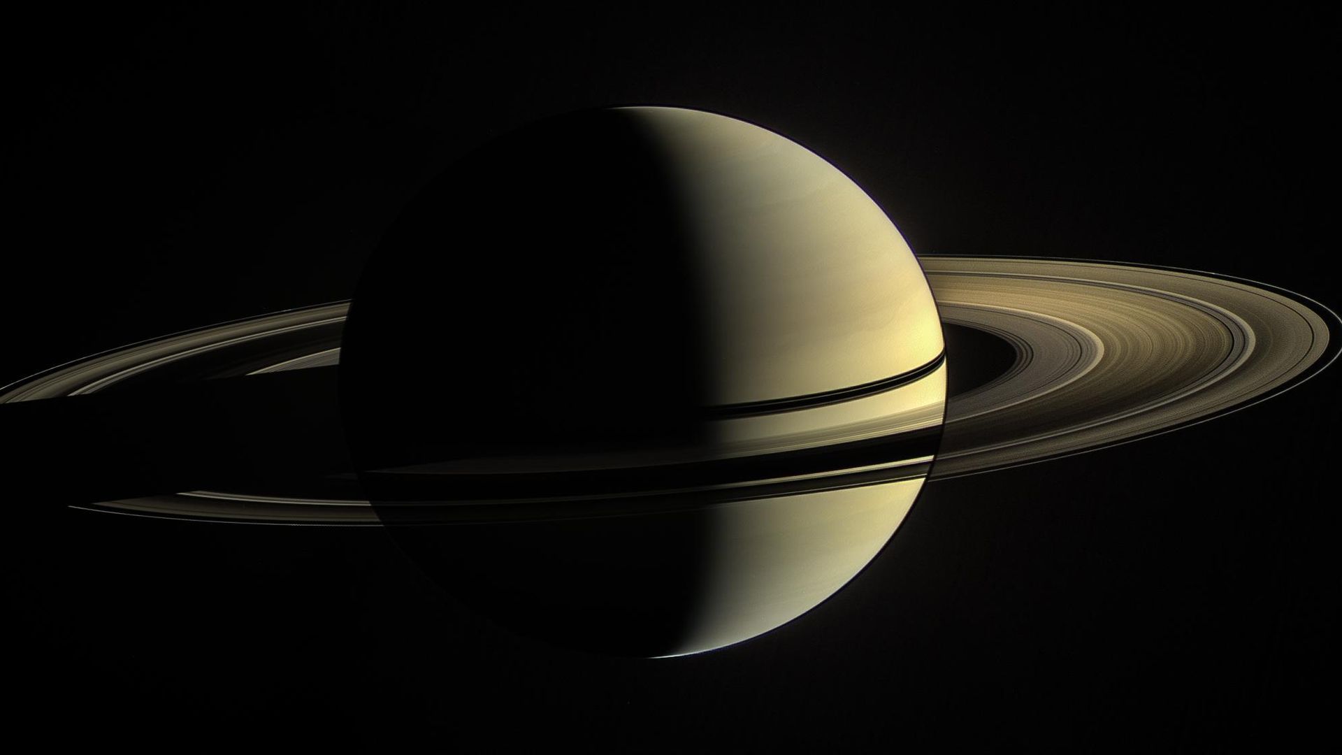 Saturn shining in yellow lit as a crescent