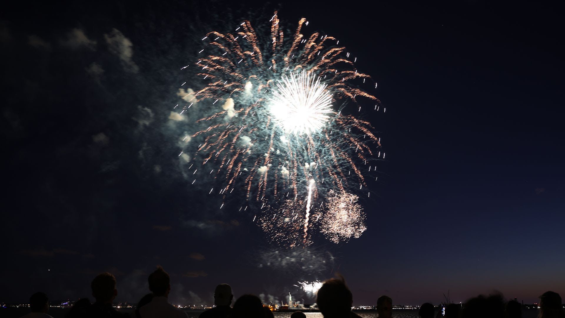 A group of people watch fireworks at night in New York City.