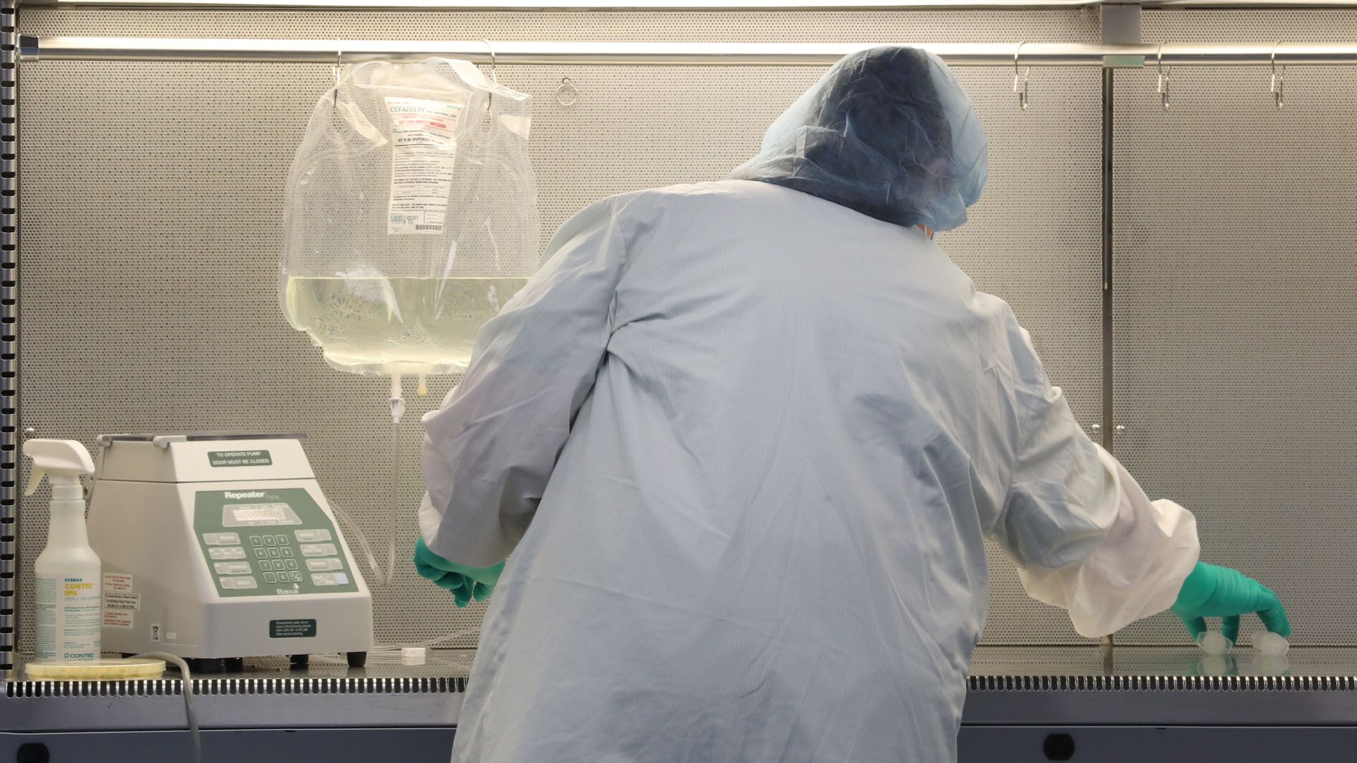 A pharmacy technician prepares an IV bag.